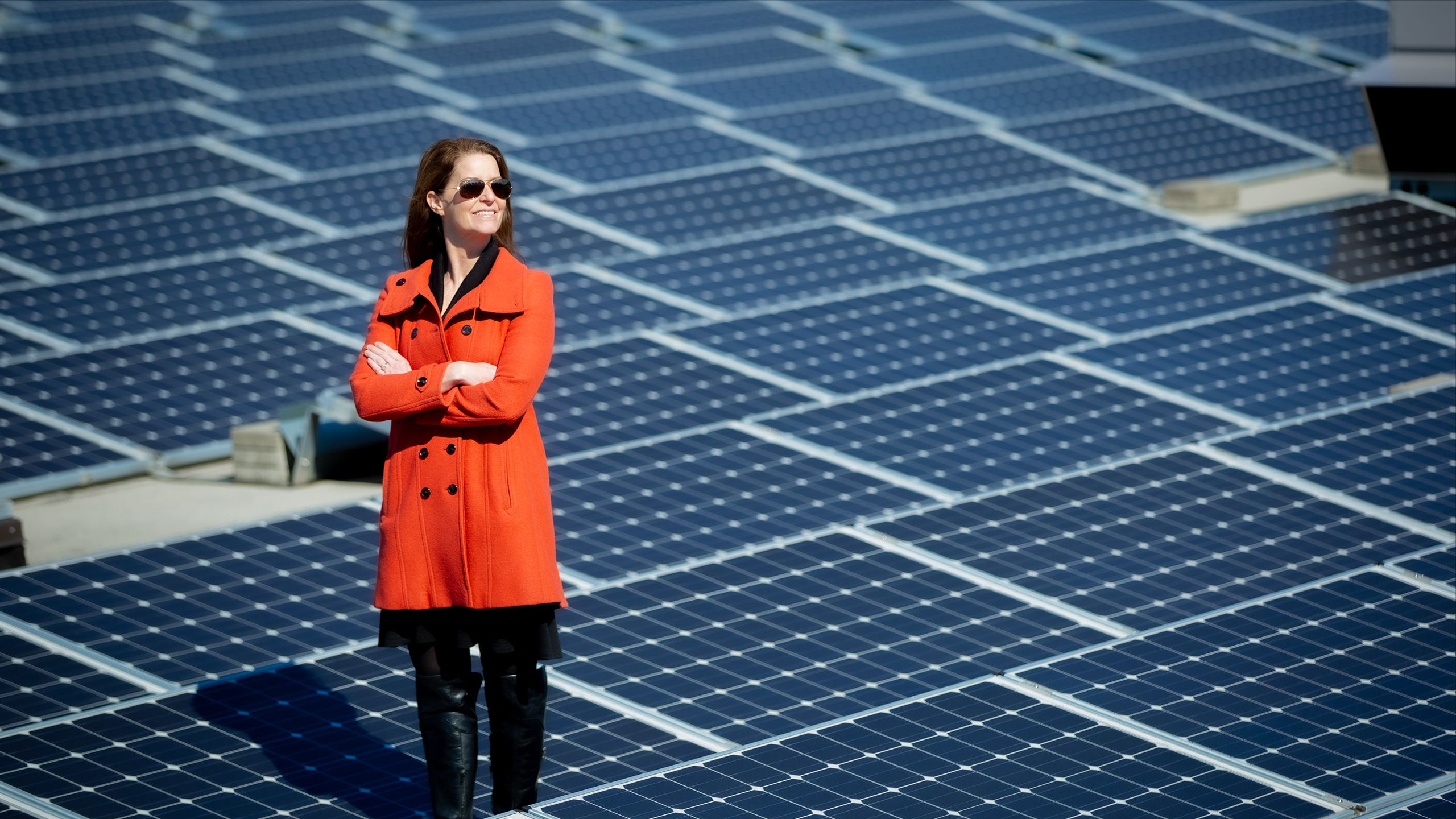 Ciannat Howett standing on top of an Emory building equipped with solar panels