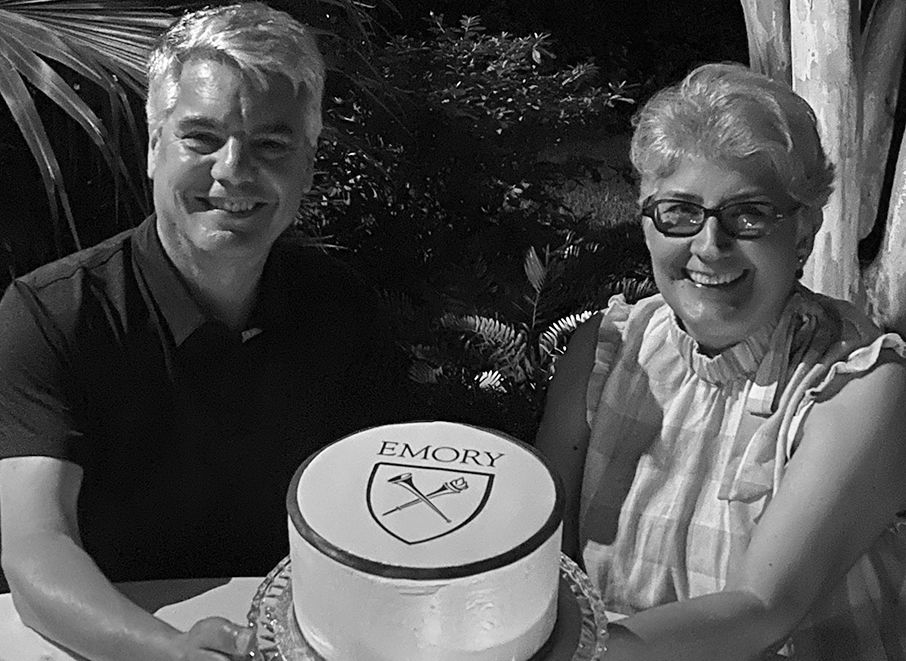 Carmel and Greg showing cake with Emory and university shield