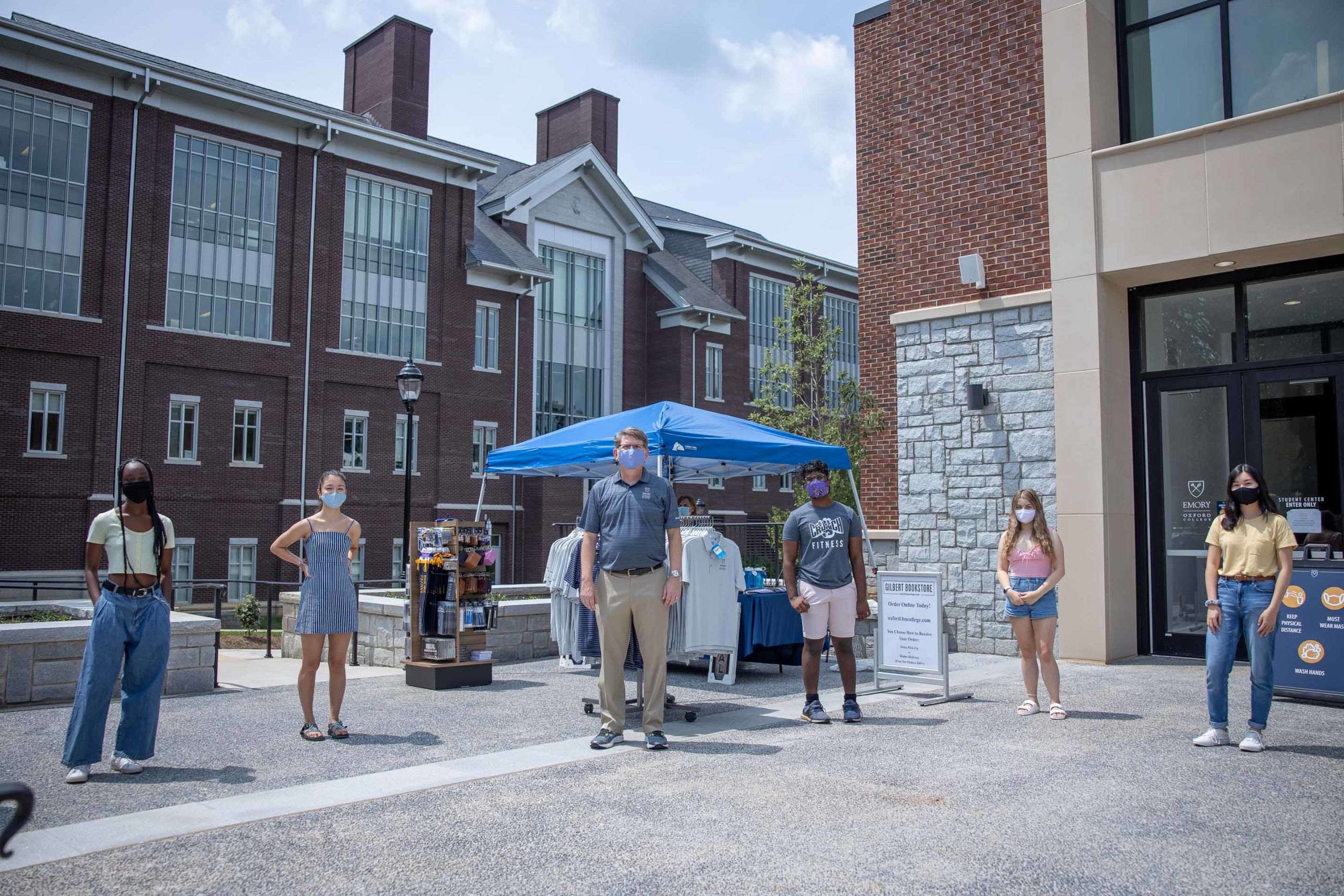 Oxford Dean Doug Hicks and students pose outside wearing face coverings and practicing physical distancing