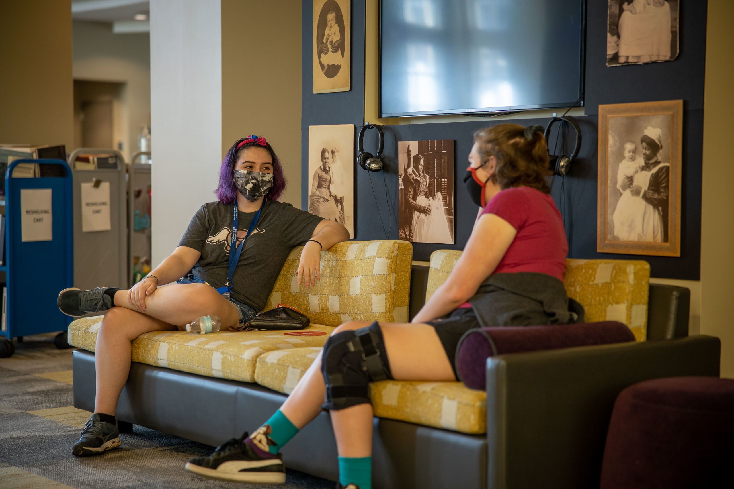 Students in face coverings sit six feet apart and talk on the Oxford campus
