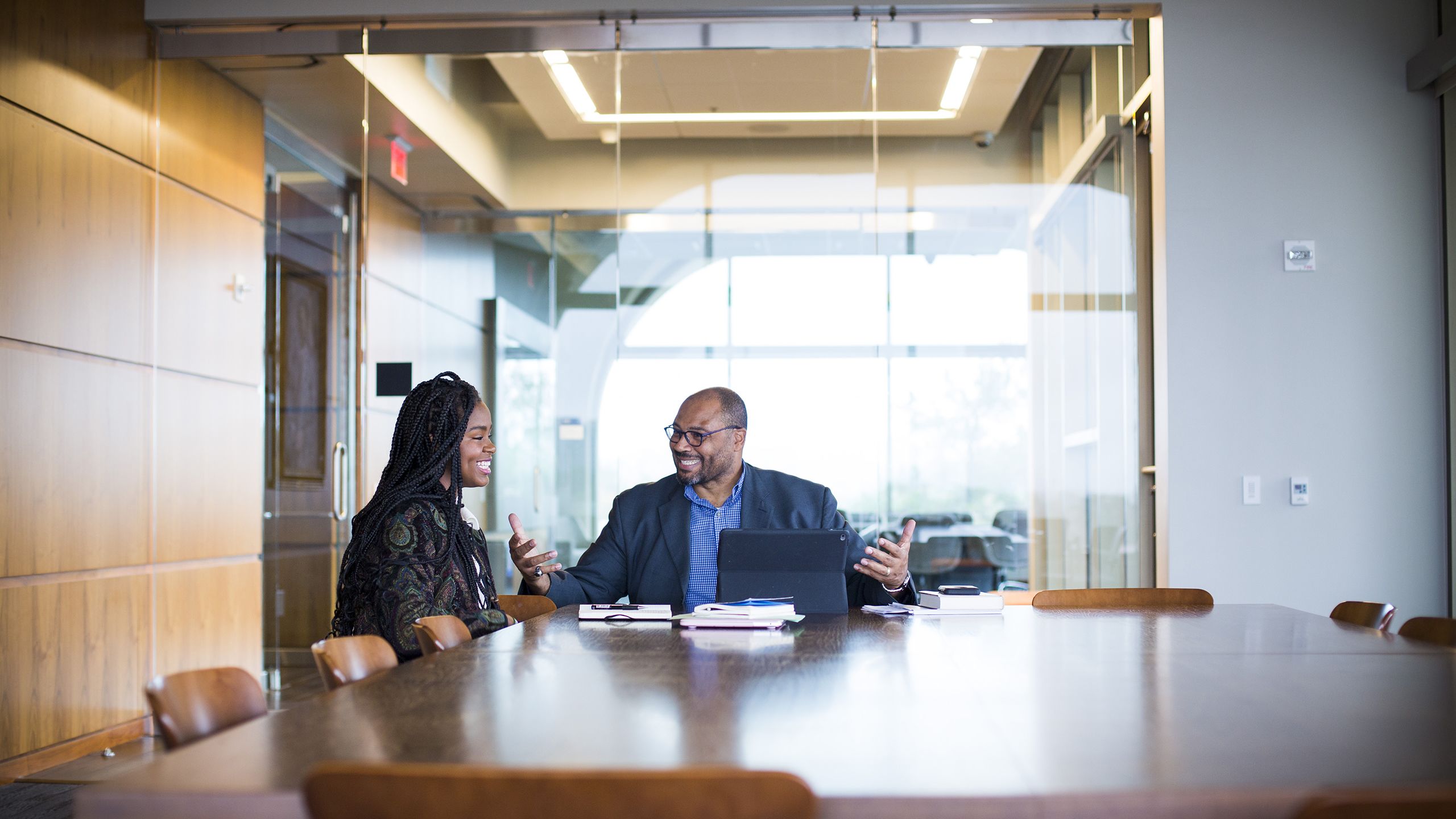 Large photo of Pellom McDAniels at a conference table with a graduate student.