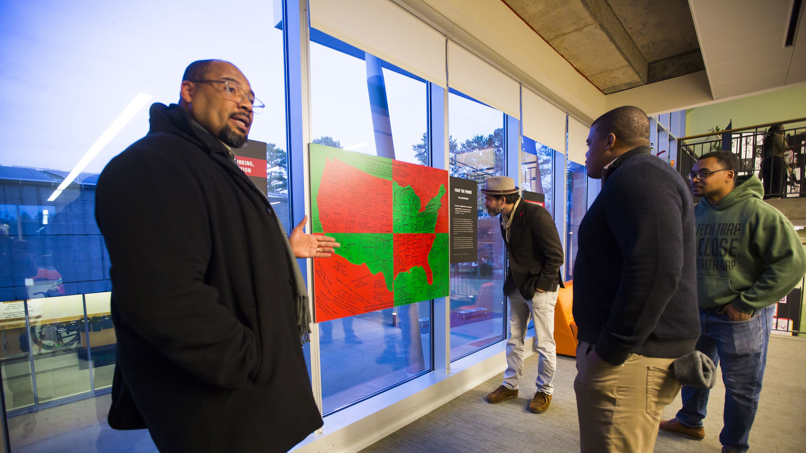 Large photo of Pellom McDaniels at an exhibit with some young students.
