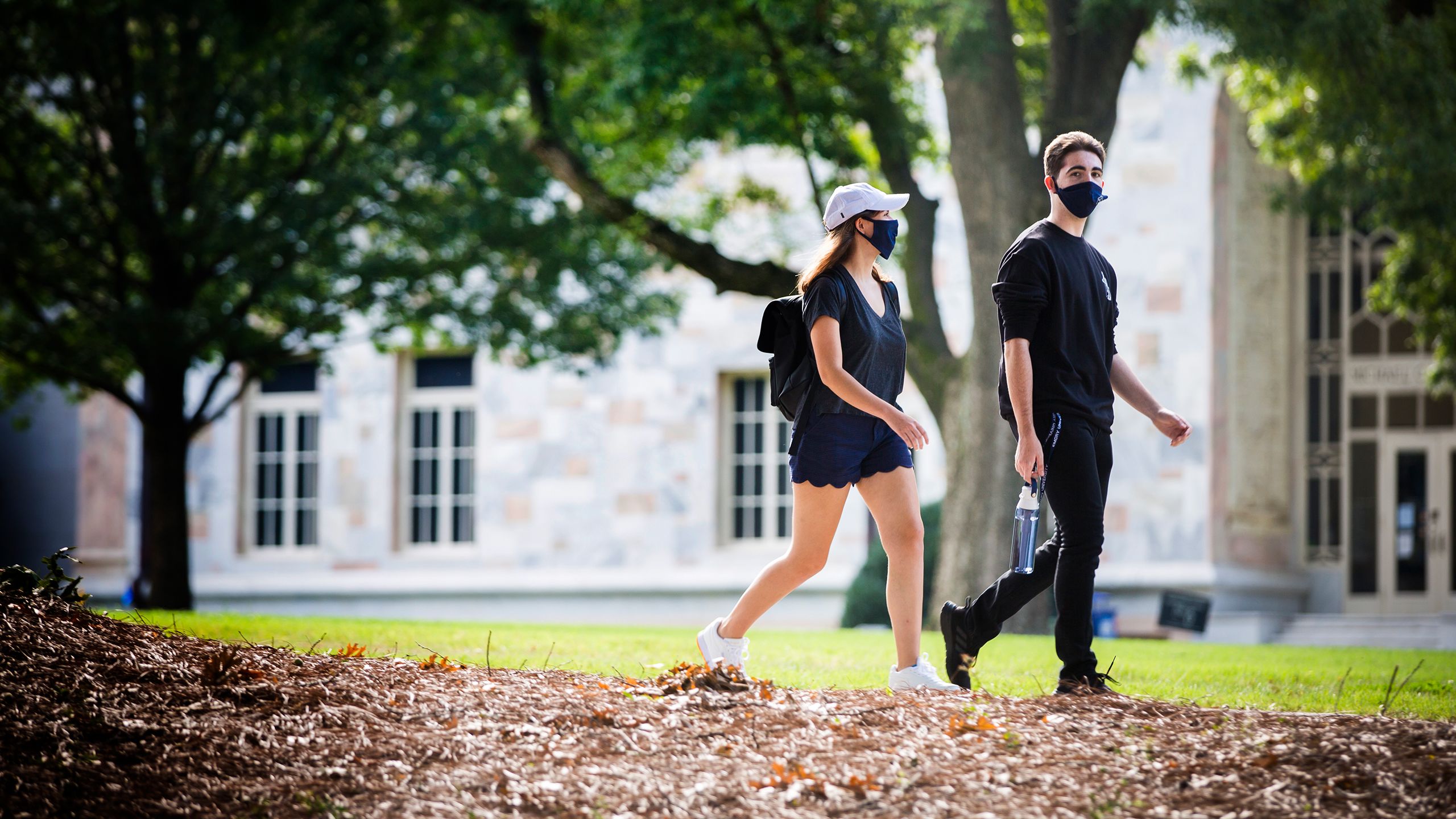 female and male Emory students walking through the QUAD