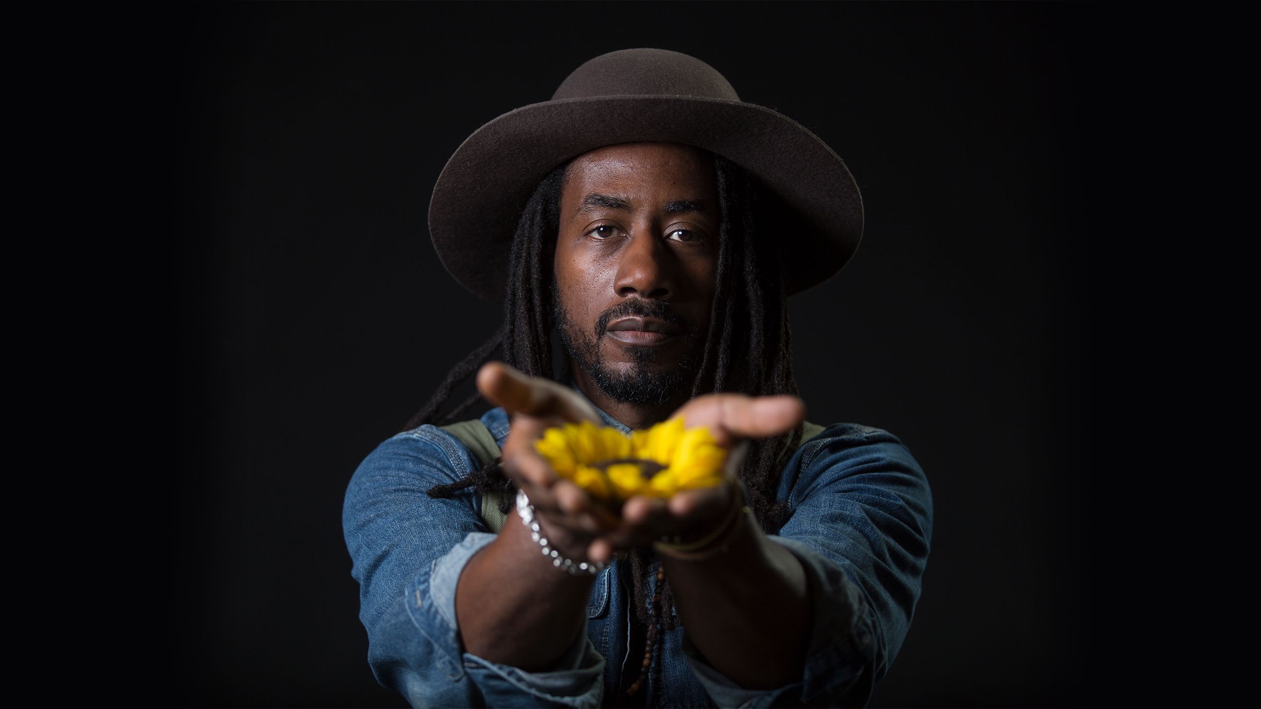 Portrait of Carlton Mackey holding a sunflower