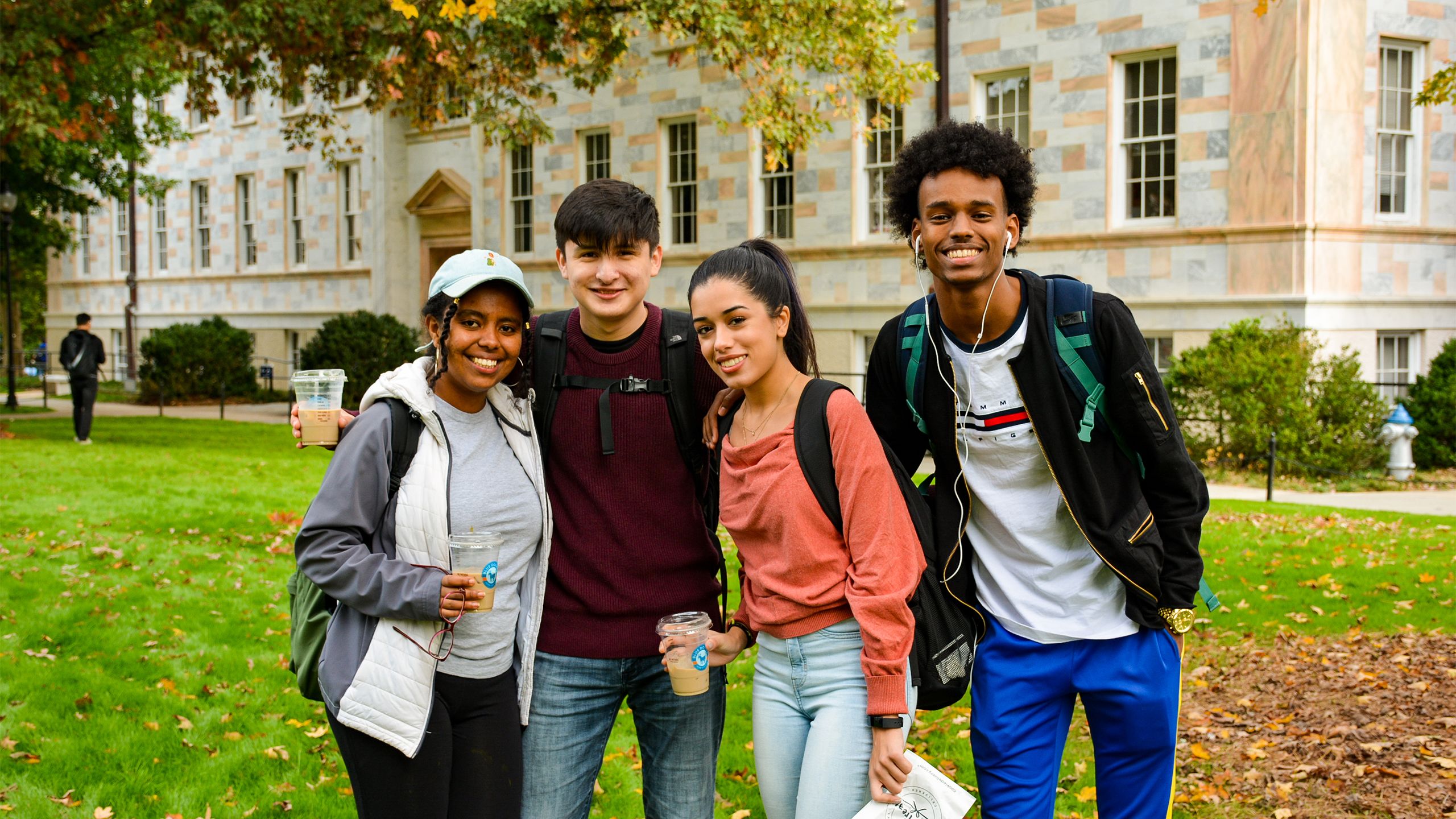 Four Emory students smile as they pose for a photo on the quad during the 2019 First-Gen Day celebration.