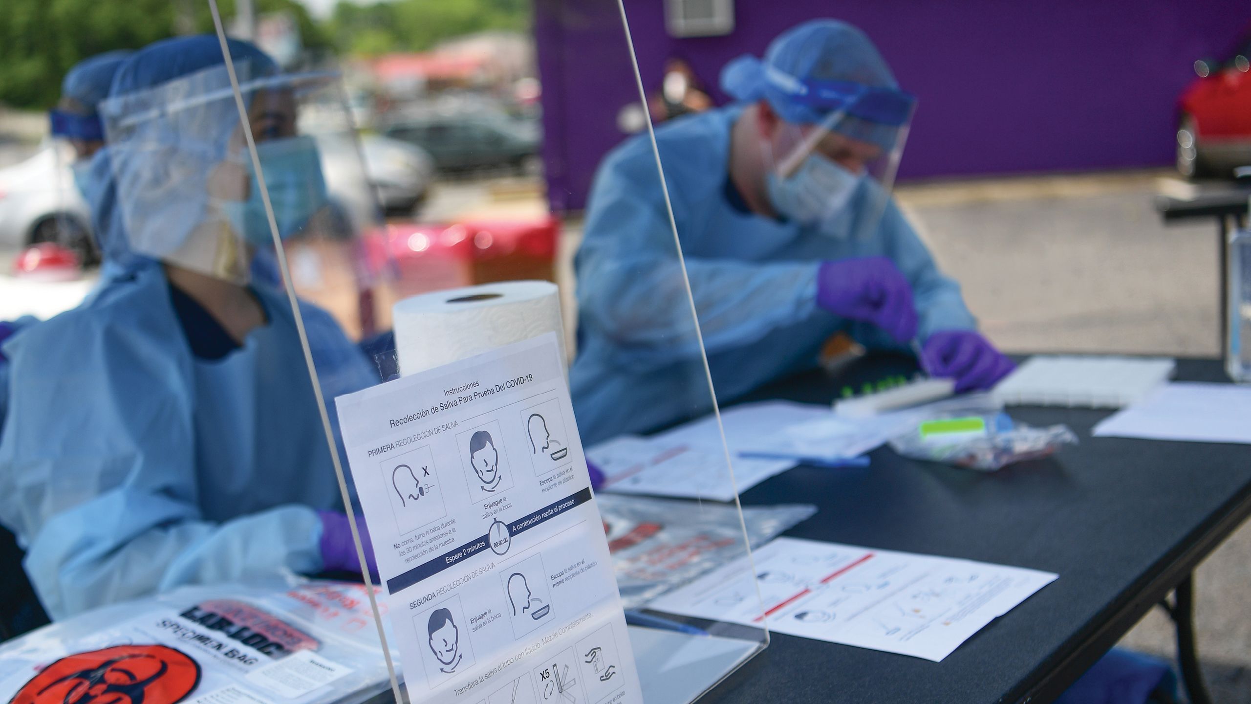 a photo from the covid testing site done during the summer in Gainesville Georgia. Two Rollins public health students are seating behind a table ready to take patients to conduct a covid-19 test. 