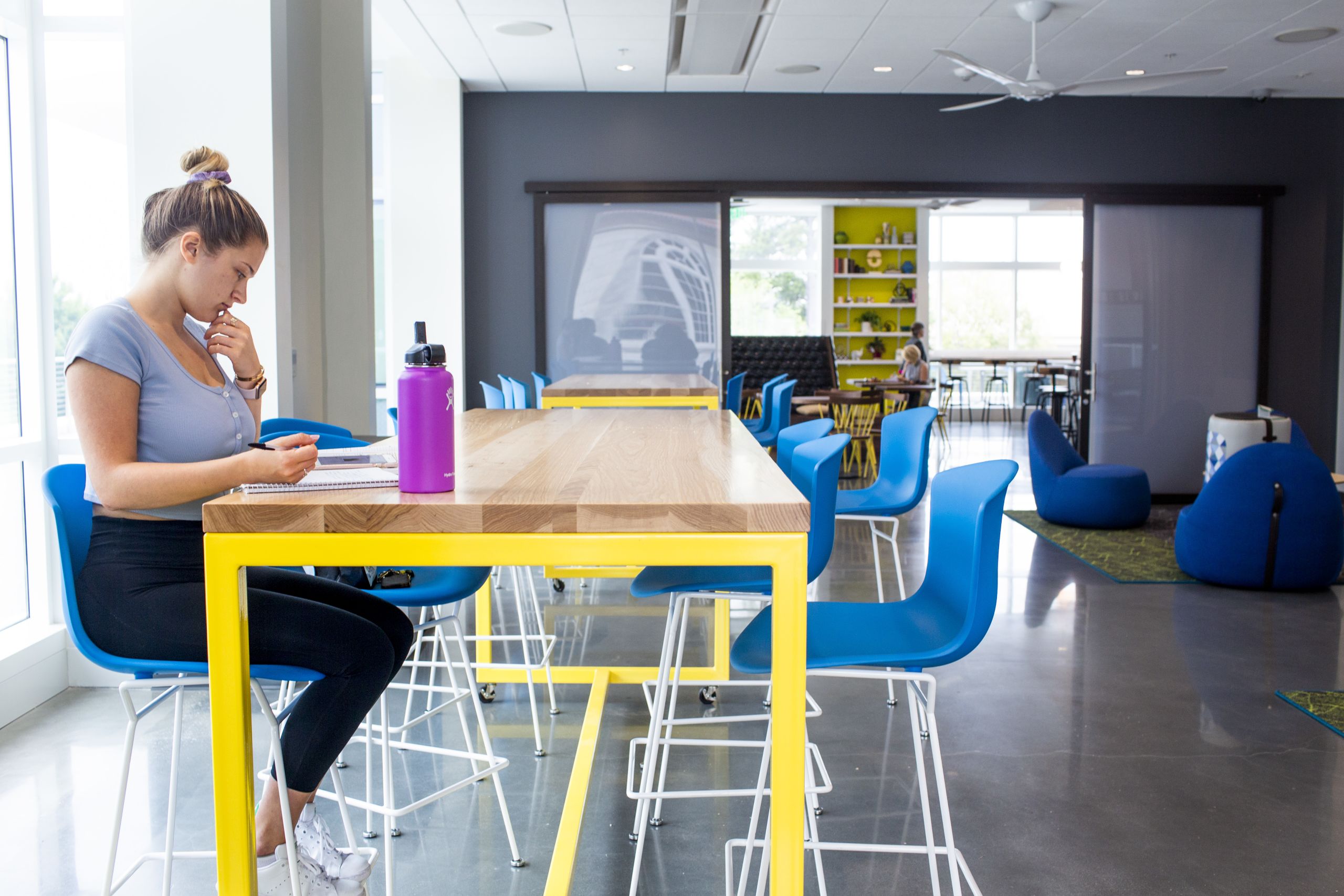 Girl reading a book at a table in the Emory Student Center