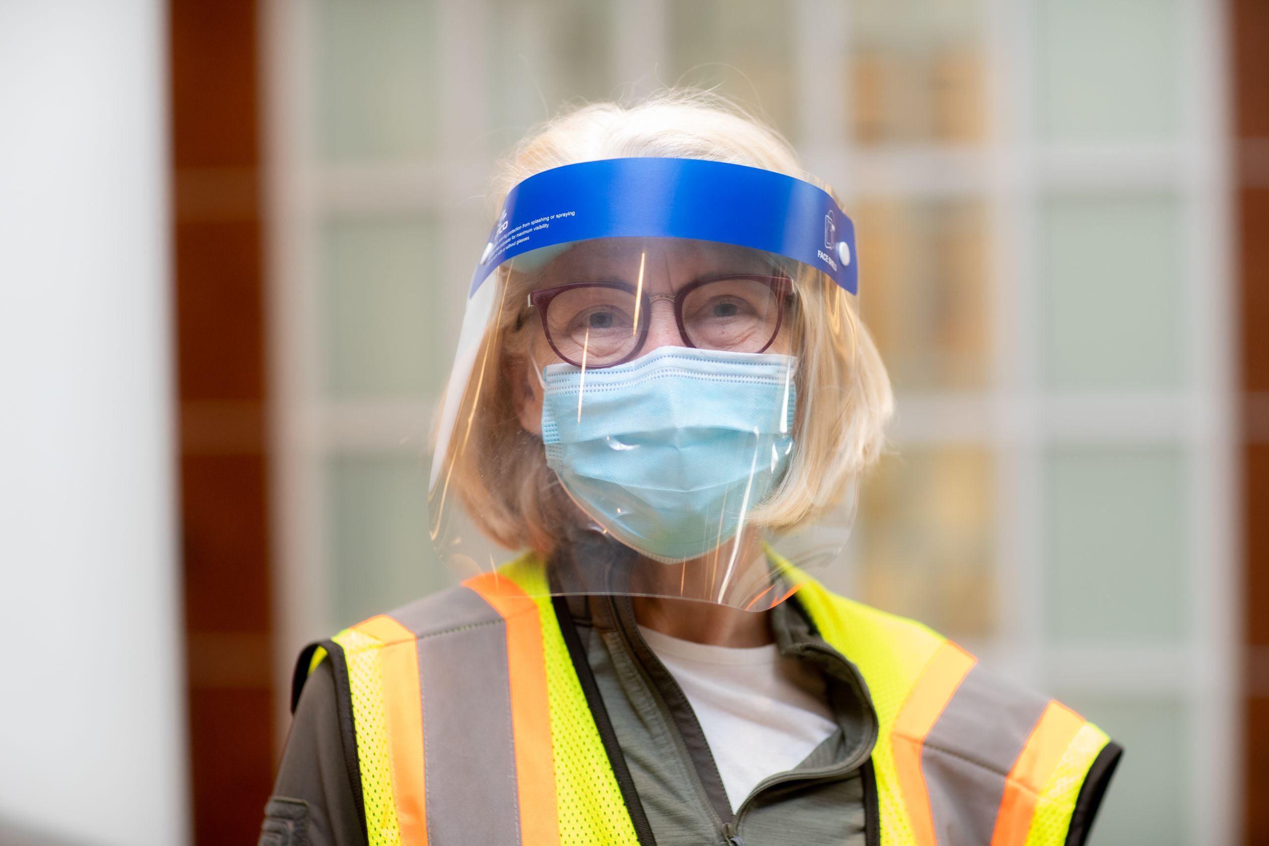 portrait of a volunteer wearing a vest and face covering