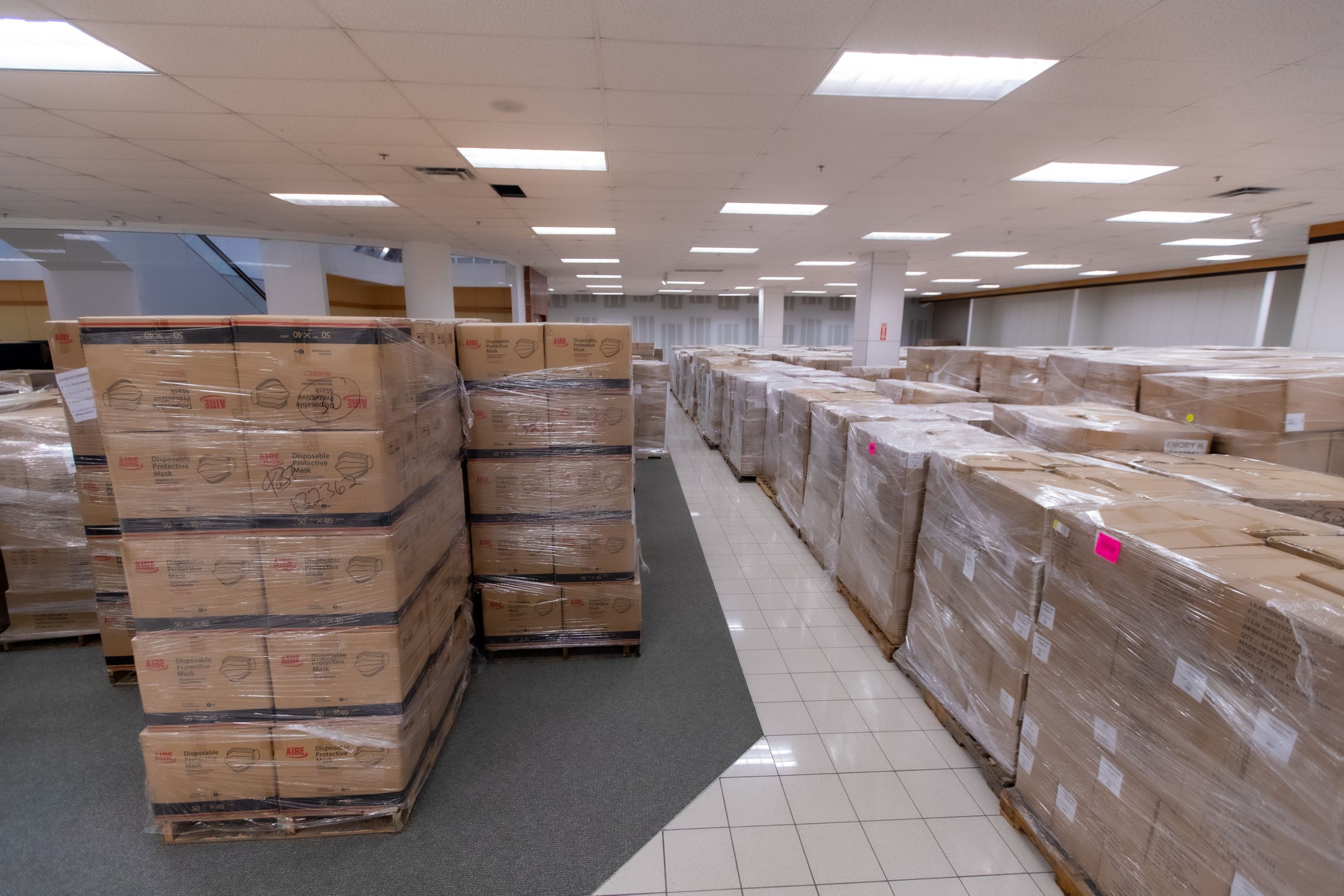 rows of supplies are stored in areas that used to hold racks of clothing when the space was a department store