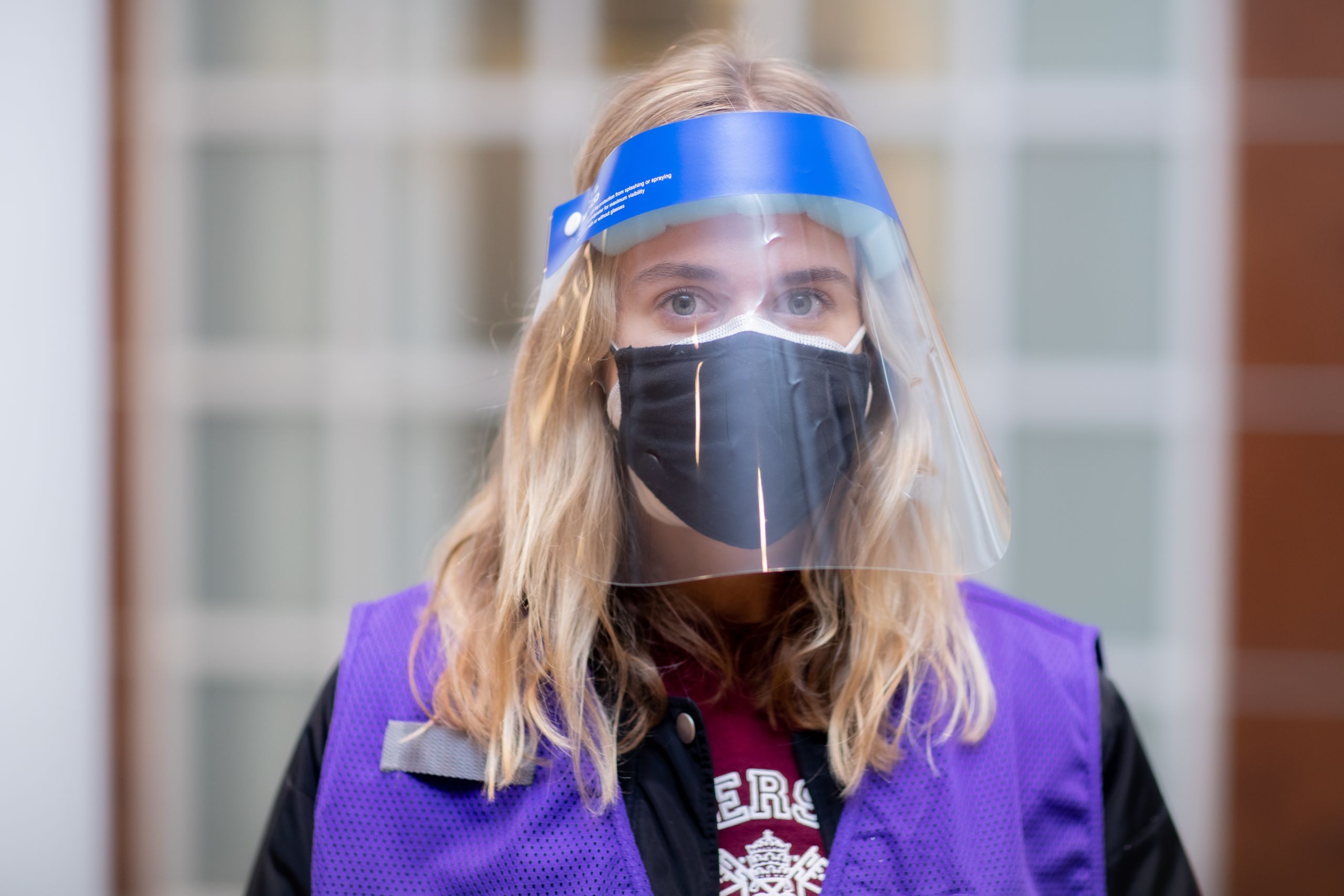 portrait of a volunteer wearing a vest and face covering