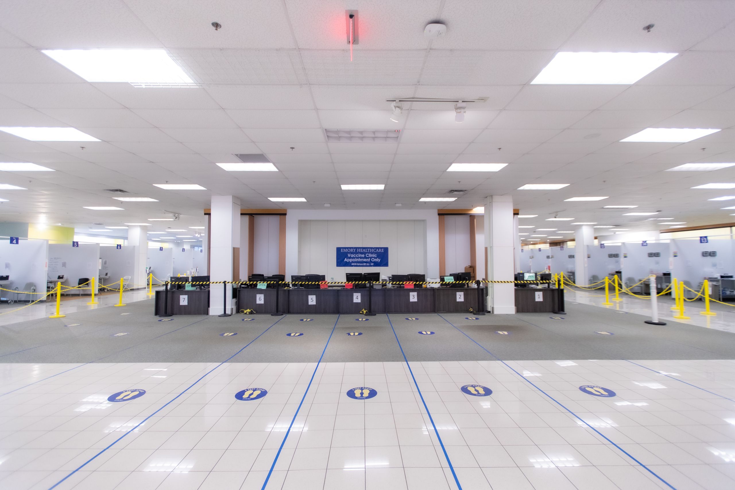 desks with lines marked on the floor waiting to check in patients