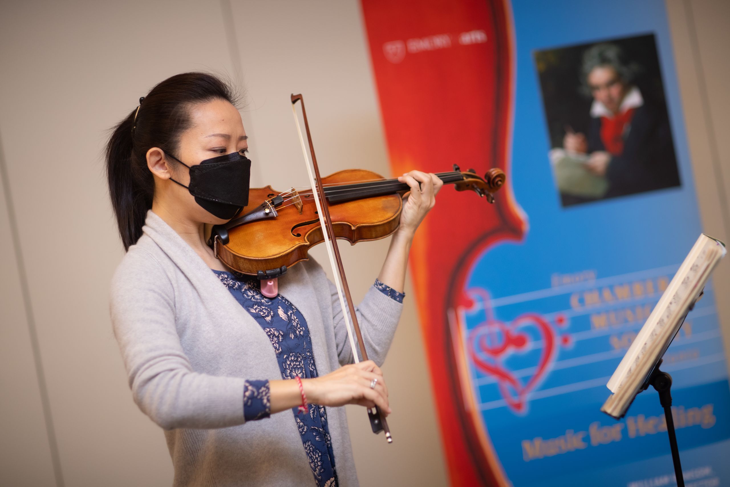 a musician plays the violin for patients at the vaccine clinic