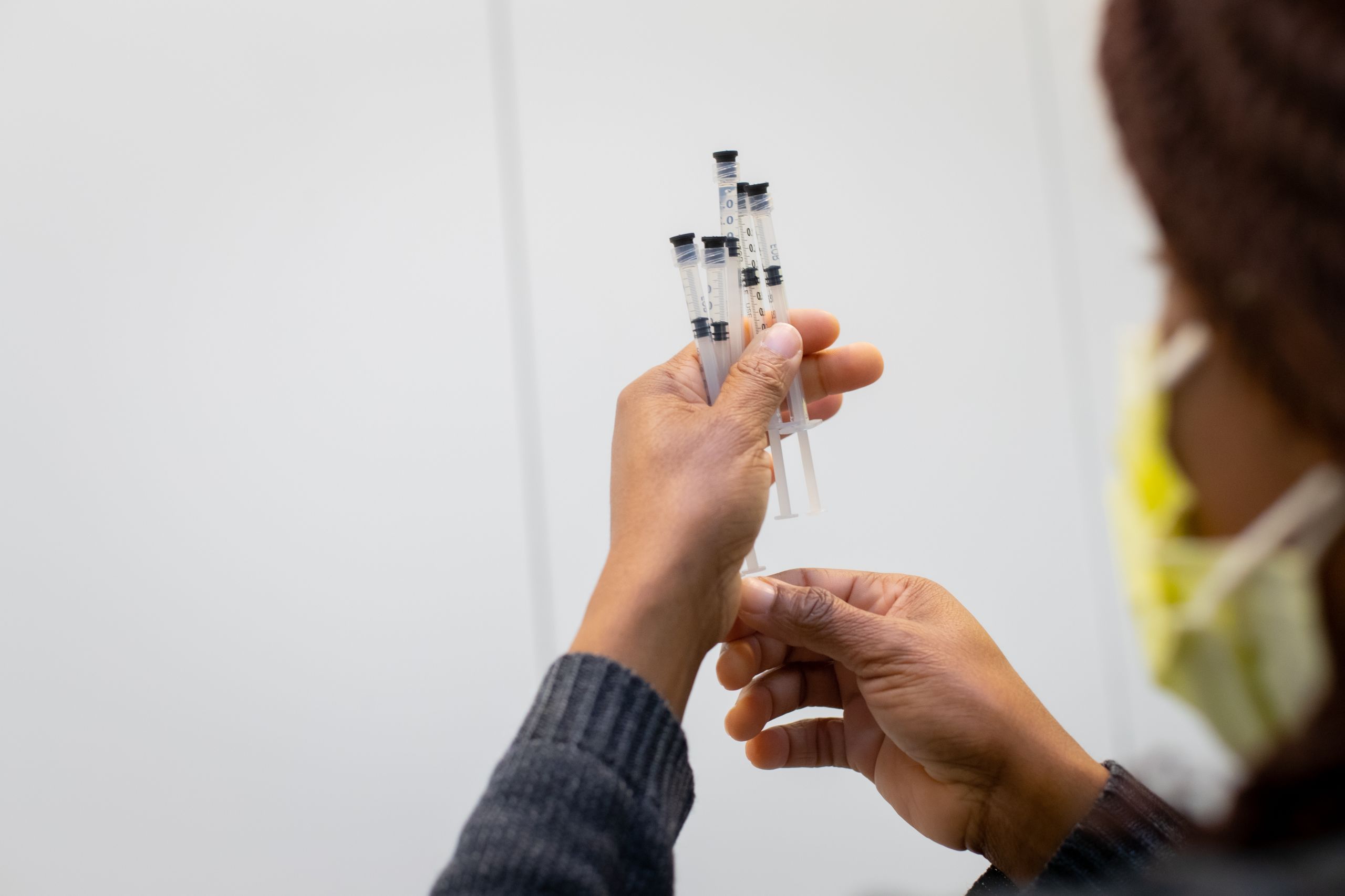 an employee holds five syringes