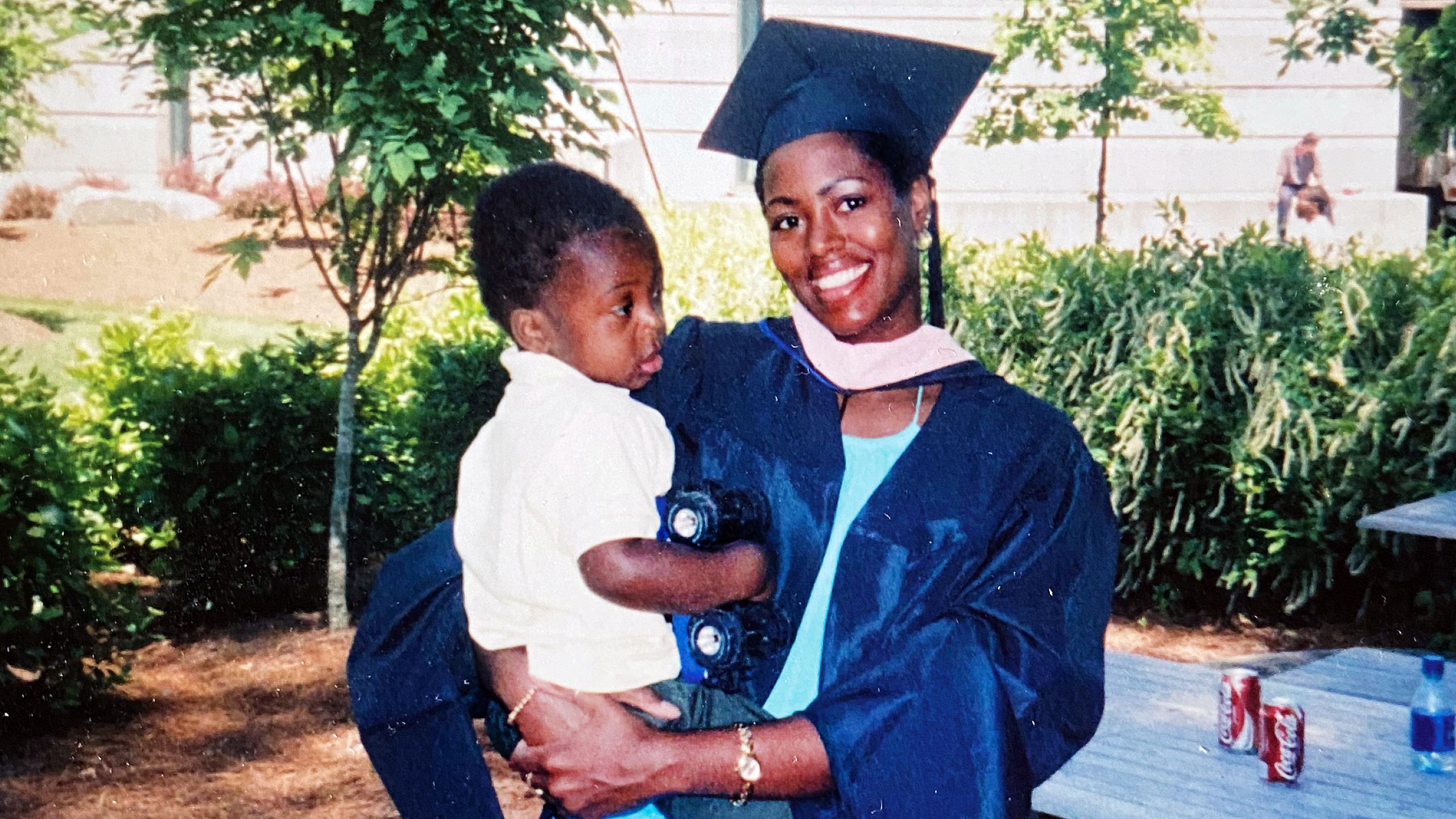 a photo of Keisha Hunt graduating from Rollins while holding her toddler son at her hip.