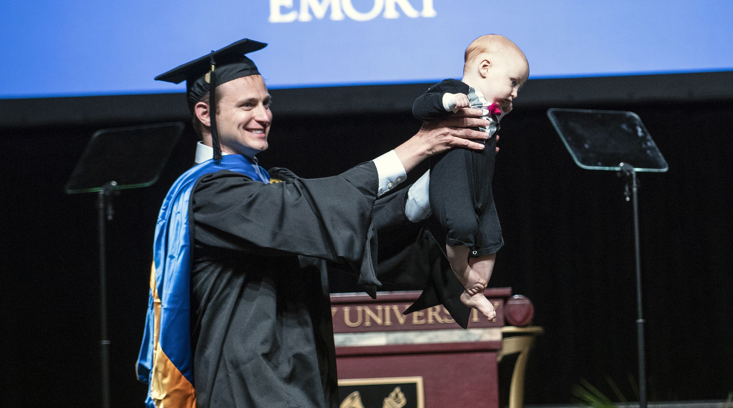 Graduate holding baby