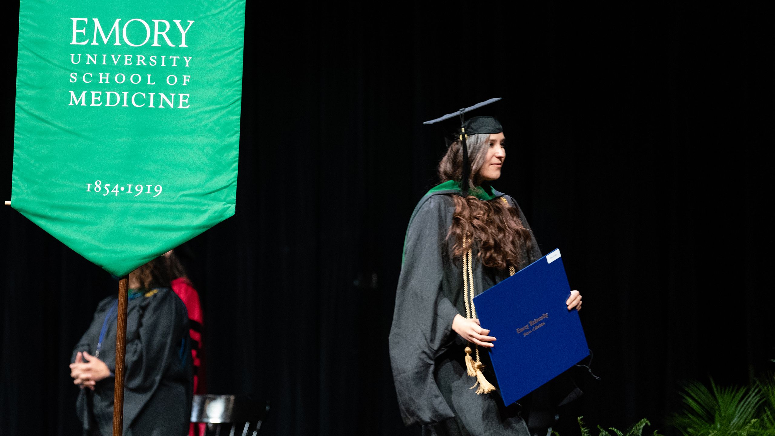 a graduate walks across the stage