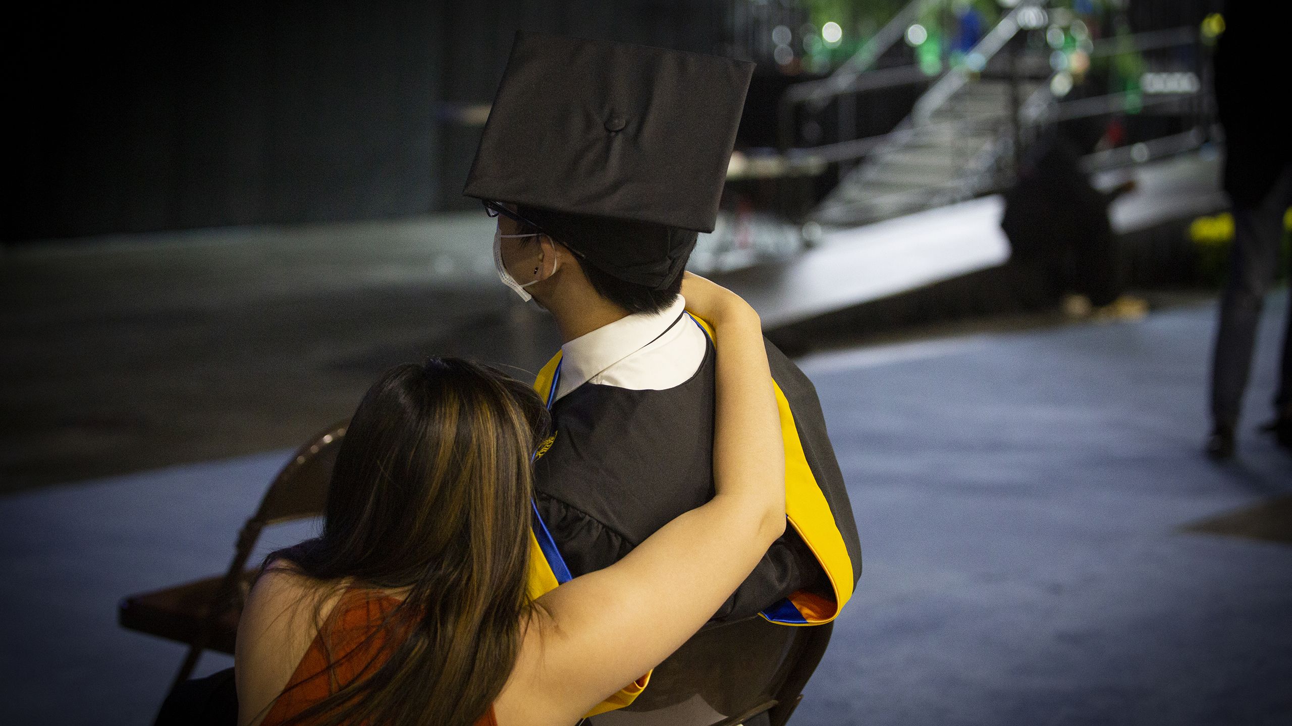 A graduate gets a hug from a loved one
