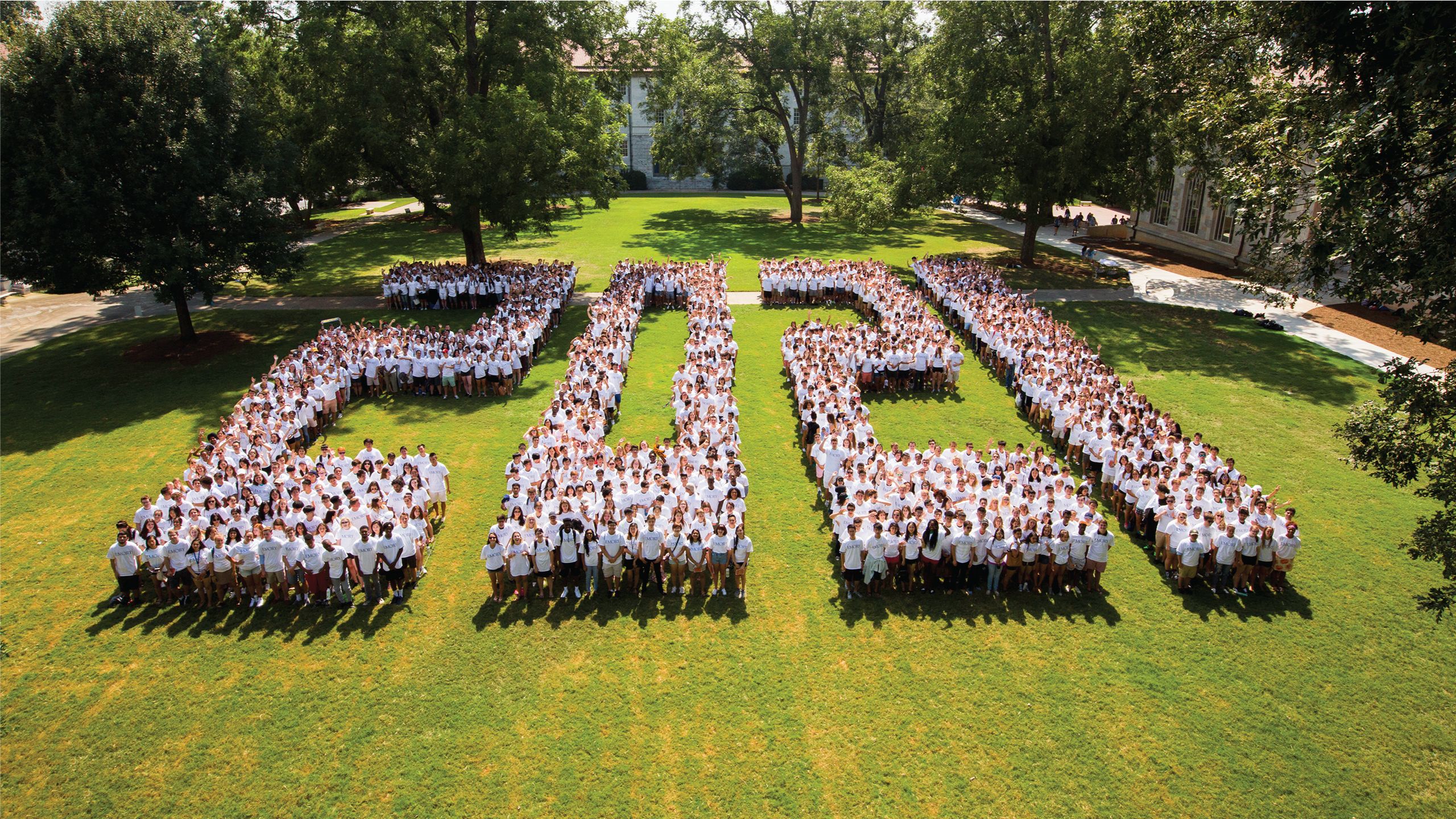 Students in white shirts form the numbers 2021 on the Quad