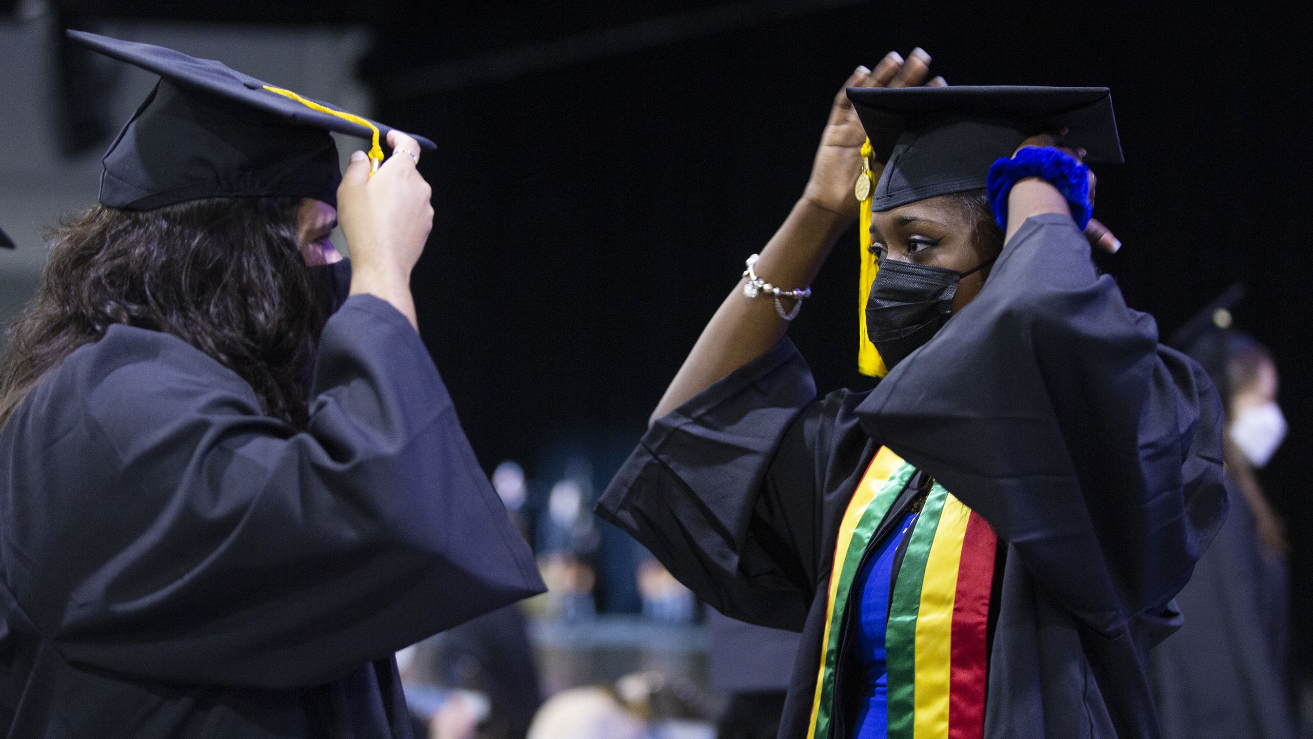 Two graduates fixing their caps