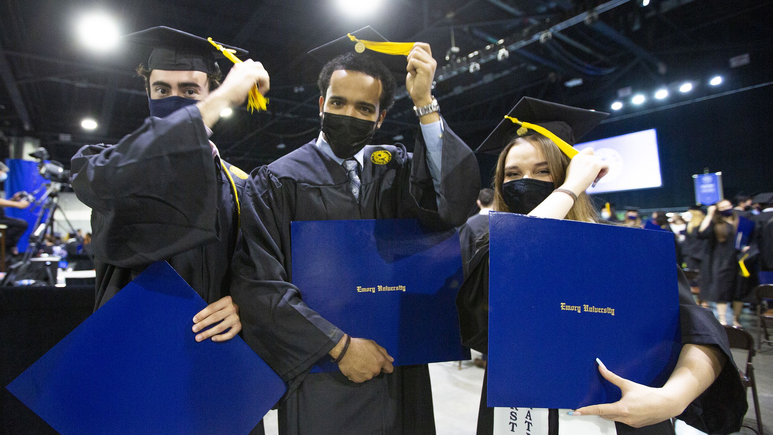 Three graduates turning their tassles