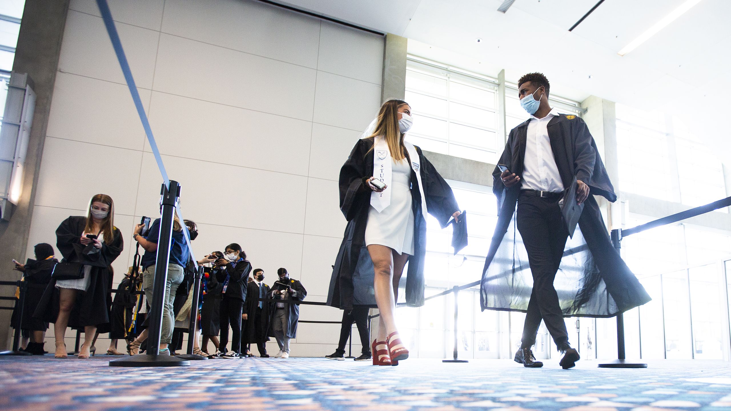 Two graduates walking inside