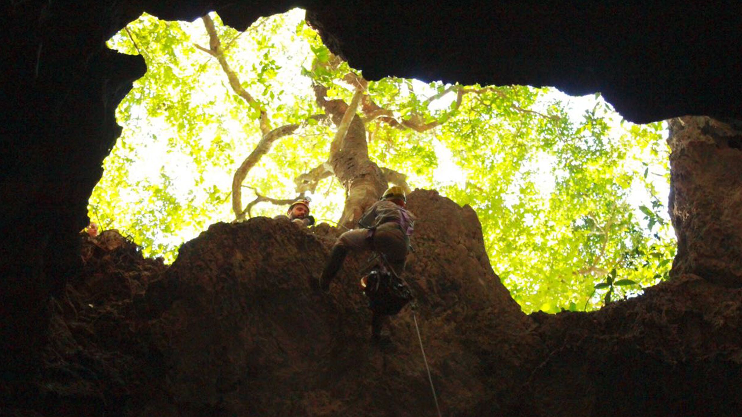 Amanda climbing out of a cave