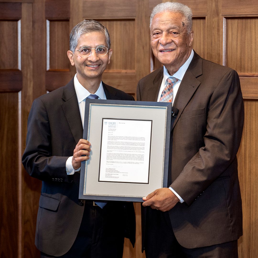 Dean Vikas Sukhatme and Dr. Marion Hood pose with framed letter.