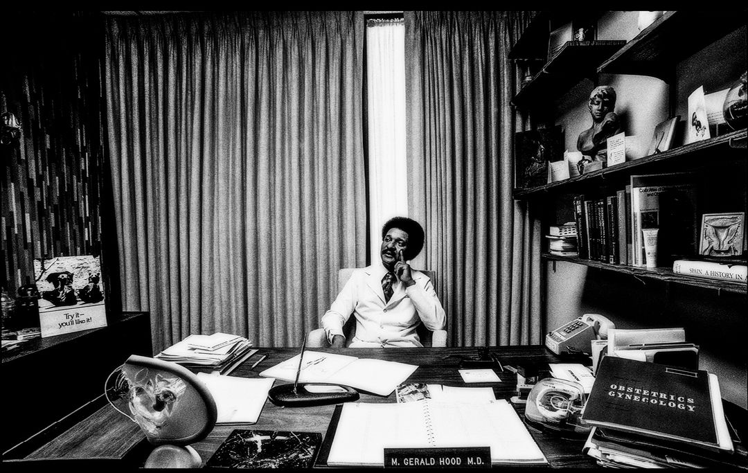 Old photo of Hood sitting at a desk.