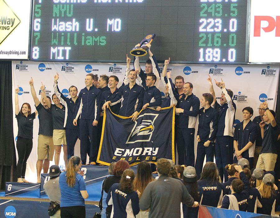 Men's swimming team holding the national championship trophy