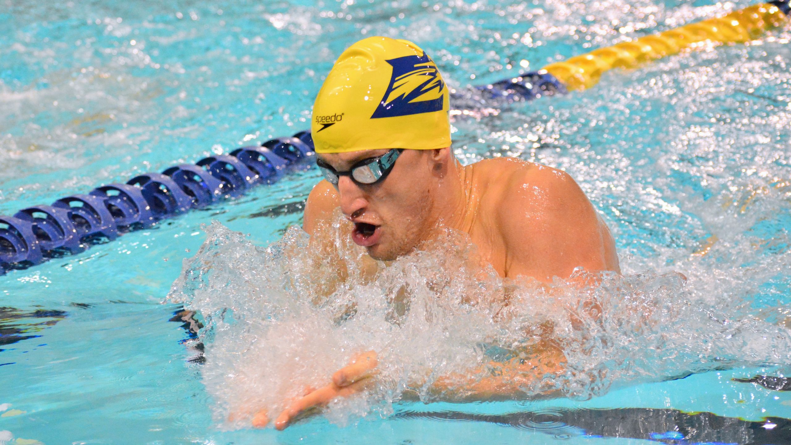 Andrew Wilson competing in breaststroke event wearing Emory swim cap