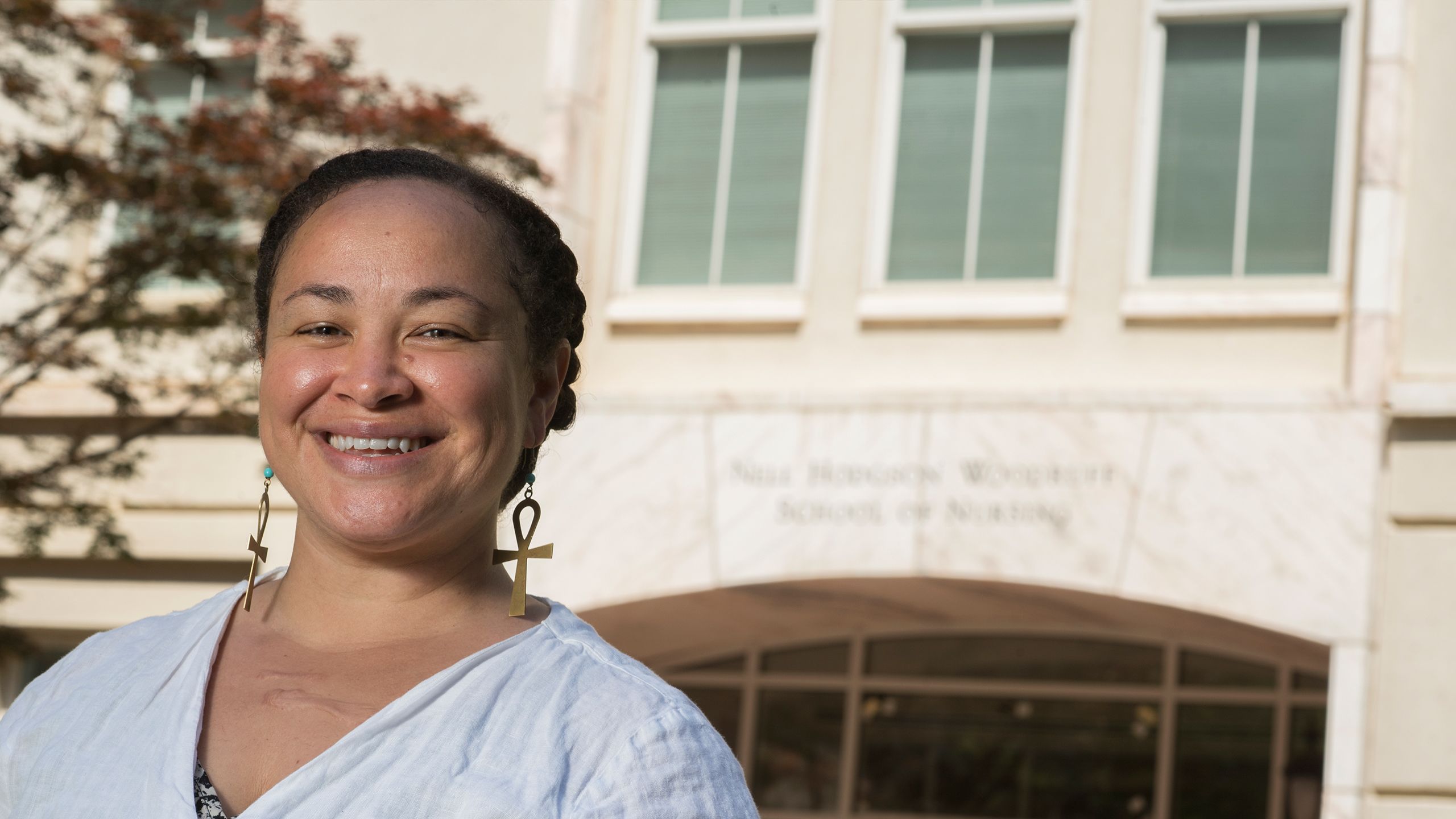 Katiana Carey-Simms smiles in front of the School of Nursing building