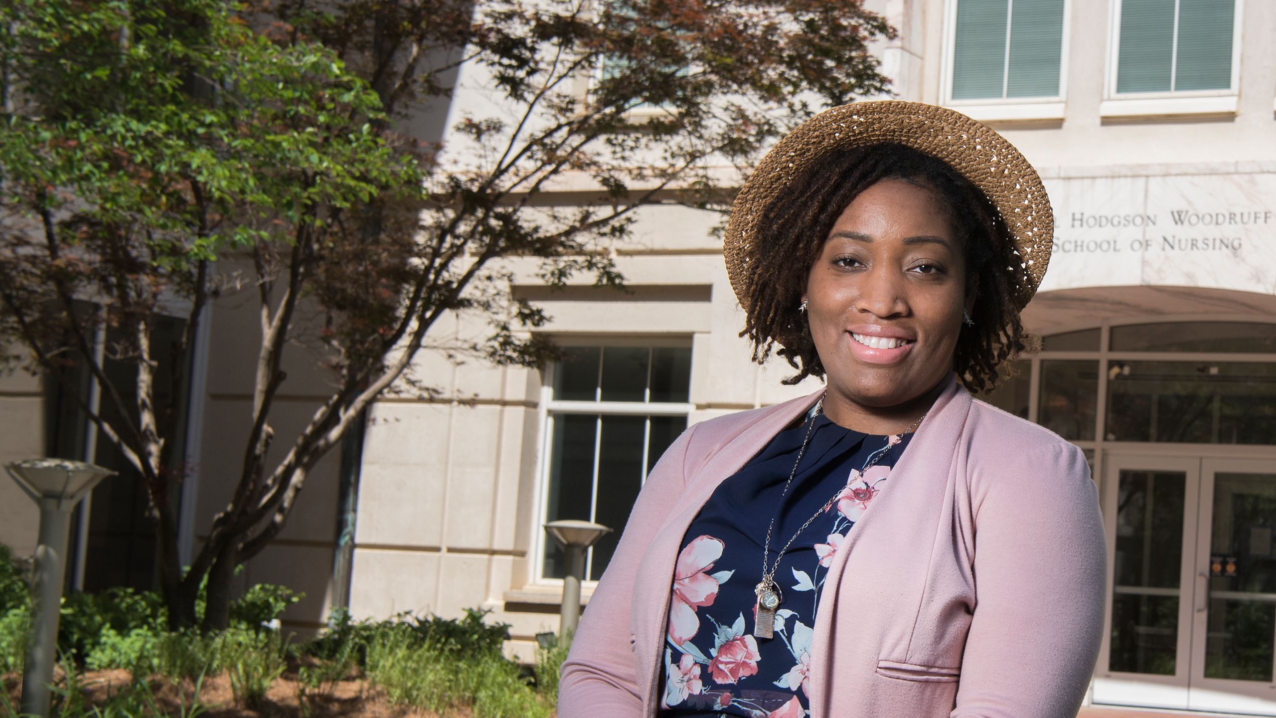 Alexis Dunn-Amore smiles in front of the School of Nursing building