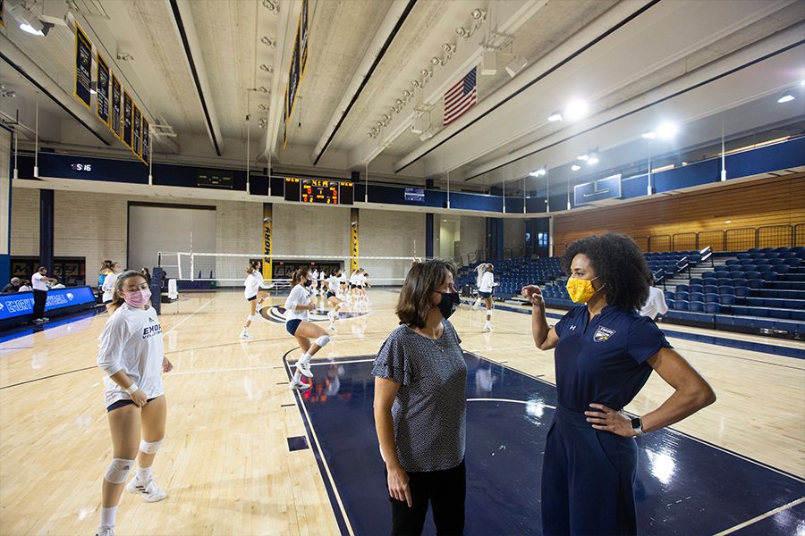 Photo of Keiko Price meeting with Emory women's volleyball coaches and players at the WoodPEC Gymnasium