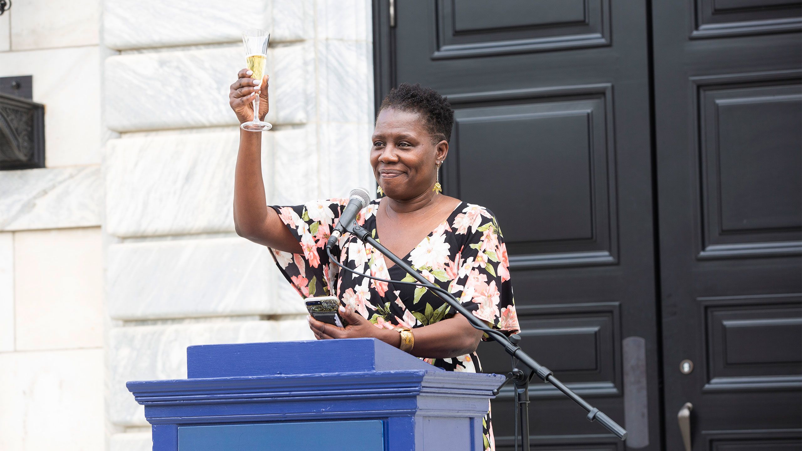Carol Henderson holds up a class with champagne