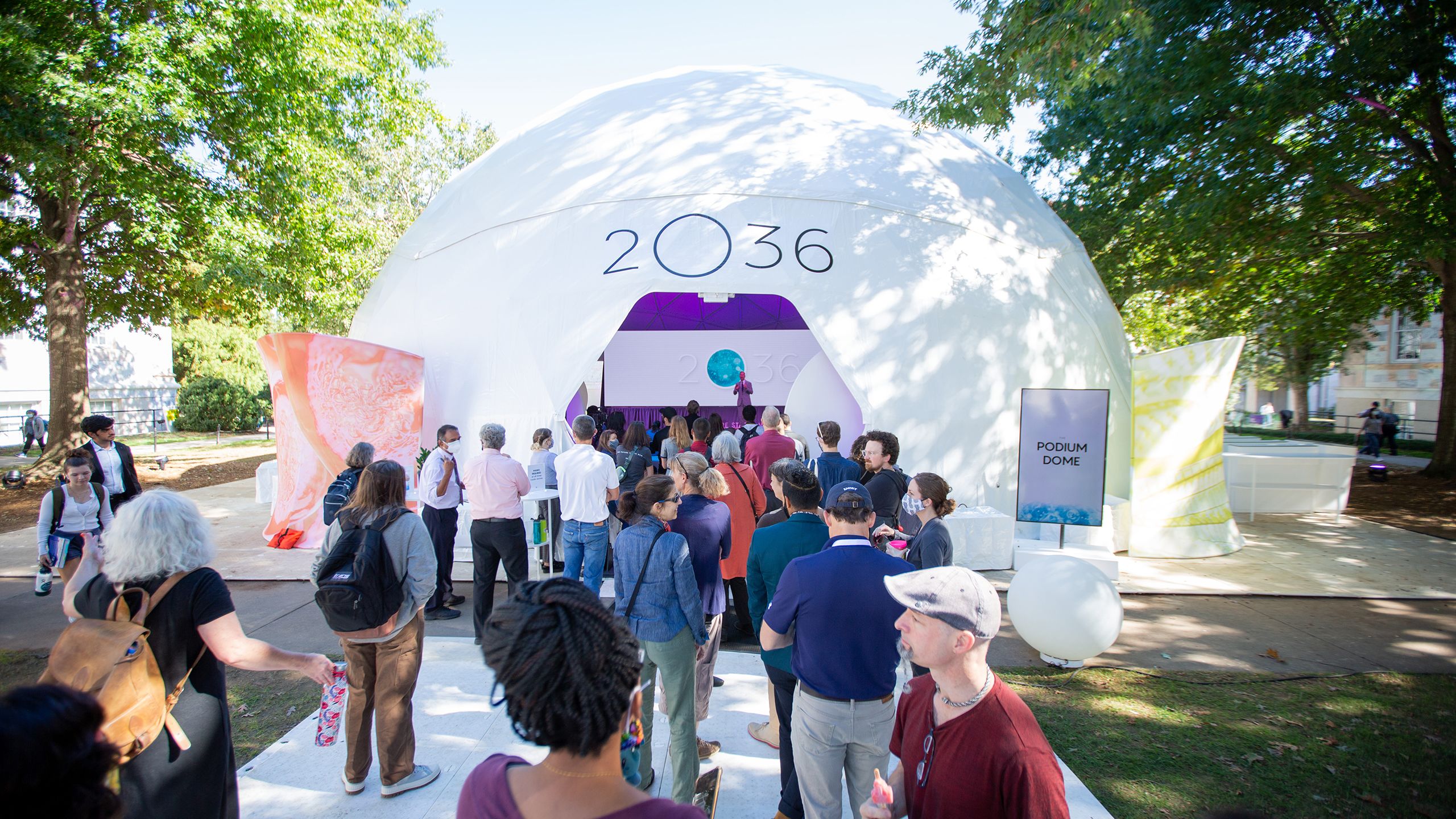 People enter a dome with 2O36 on the outside.