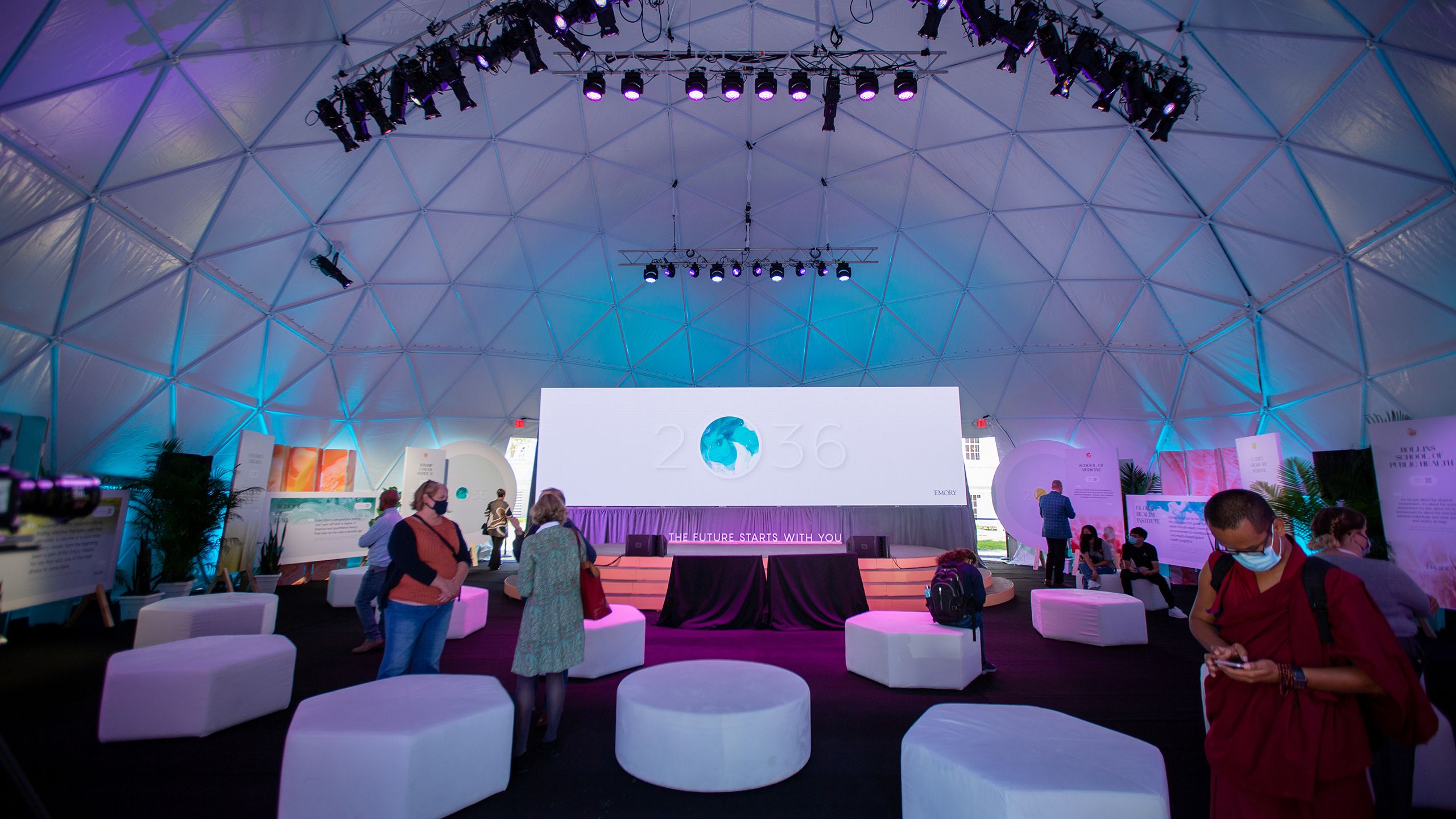Inside of the podium dome, with 2O36 projected on a screen and people mingling