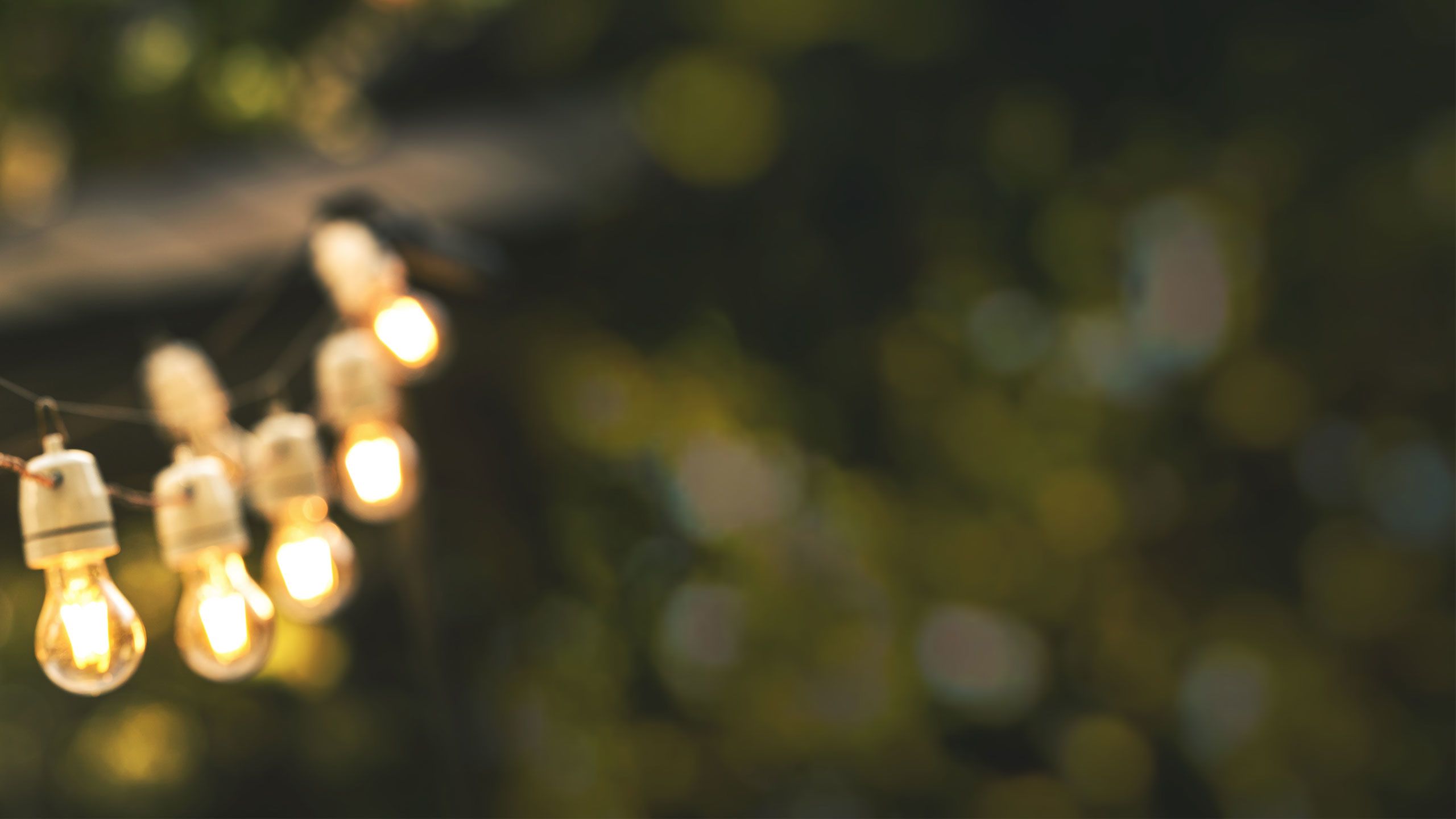 a blurred image of warm string lights and a green background