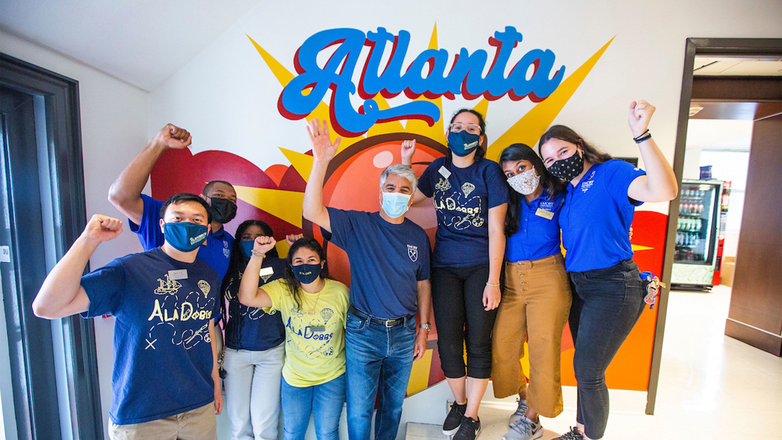 President Gregory L. Fenves poses with students in front of an Atlanta mural in a residence hall on Move In Day