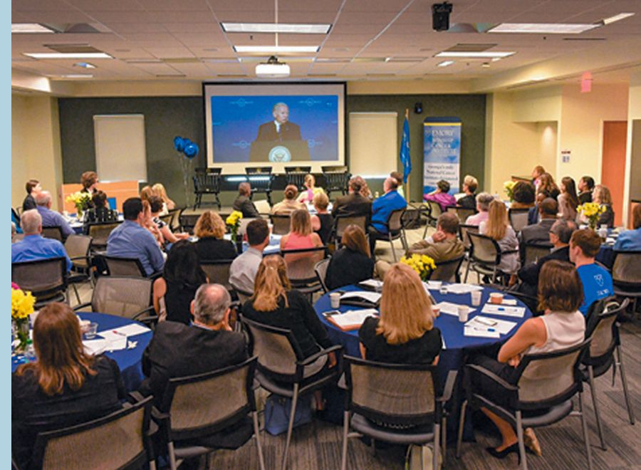 Room of people watching Cancer Moonshot initiative announcement