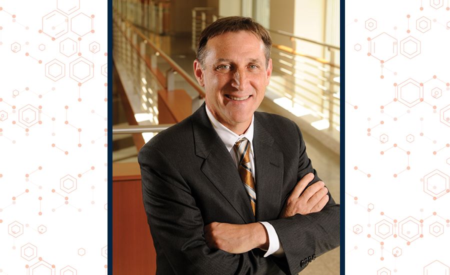 a portrait of Chris larsen standing with his arms crossed in a hallway at the emory school of medicine building.