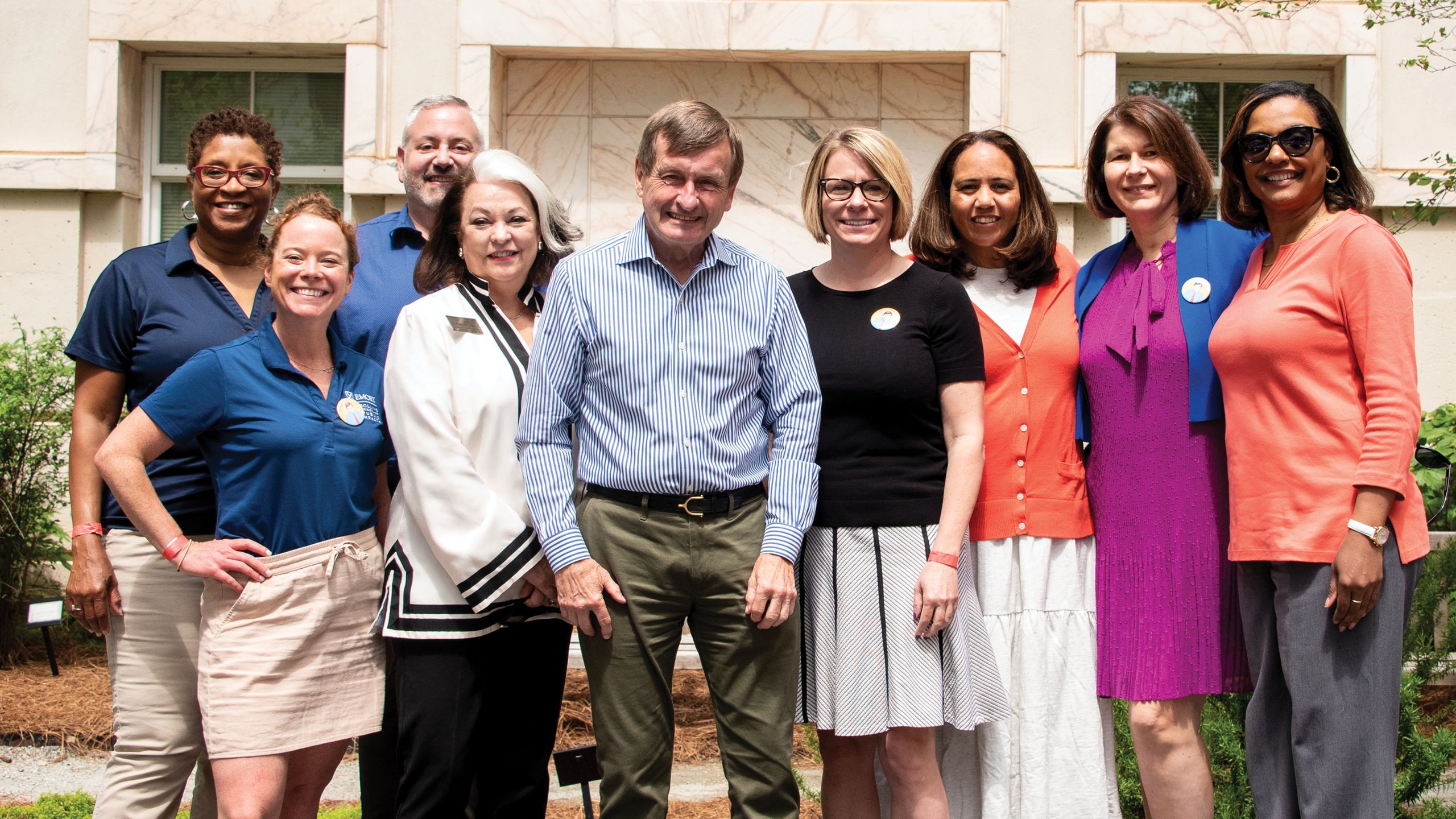 A group of seven women an two men pose. 