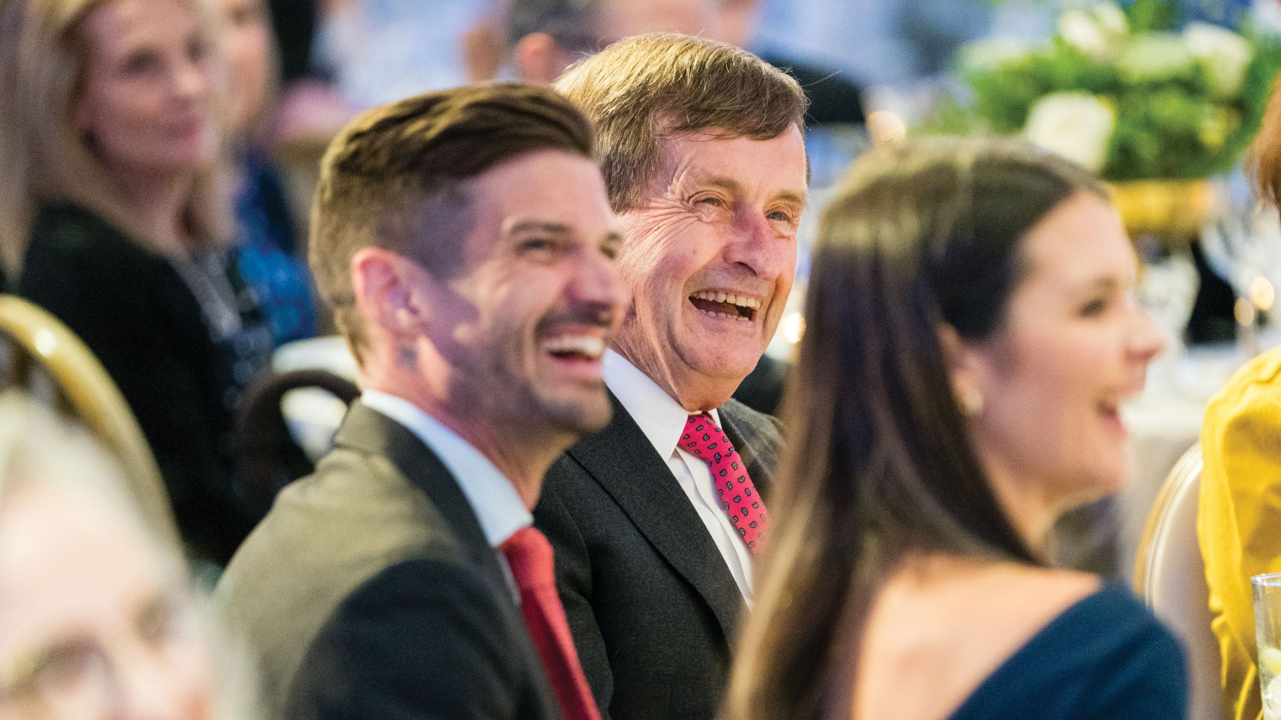 Two men and one woman laugh