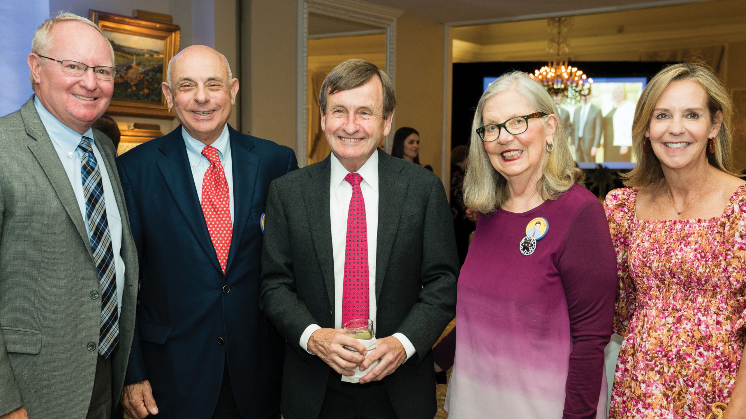 Three men and two women pose