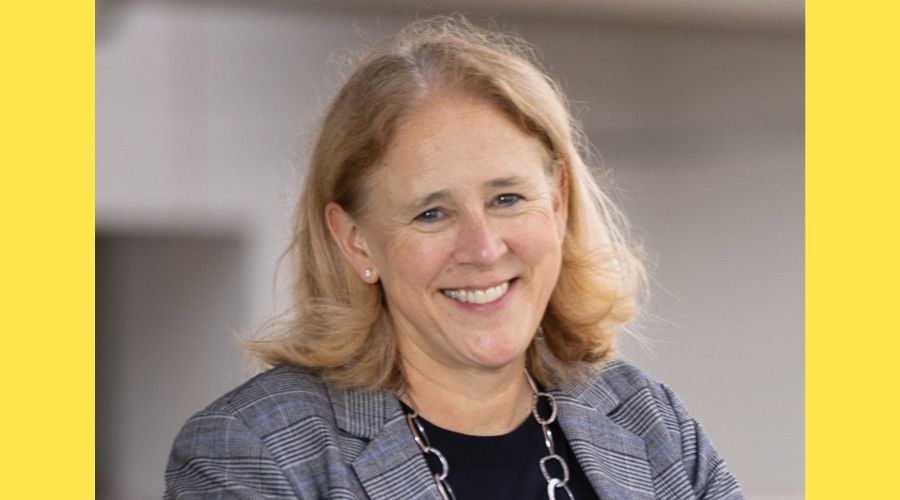A portrait of a woman smiling to the camera.