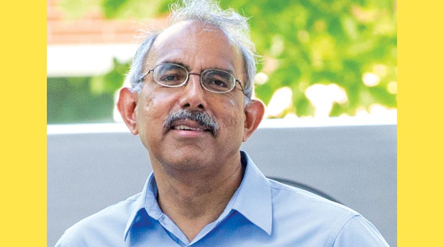 A portrait of Narayan smiling to the camera.