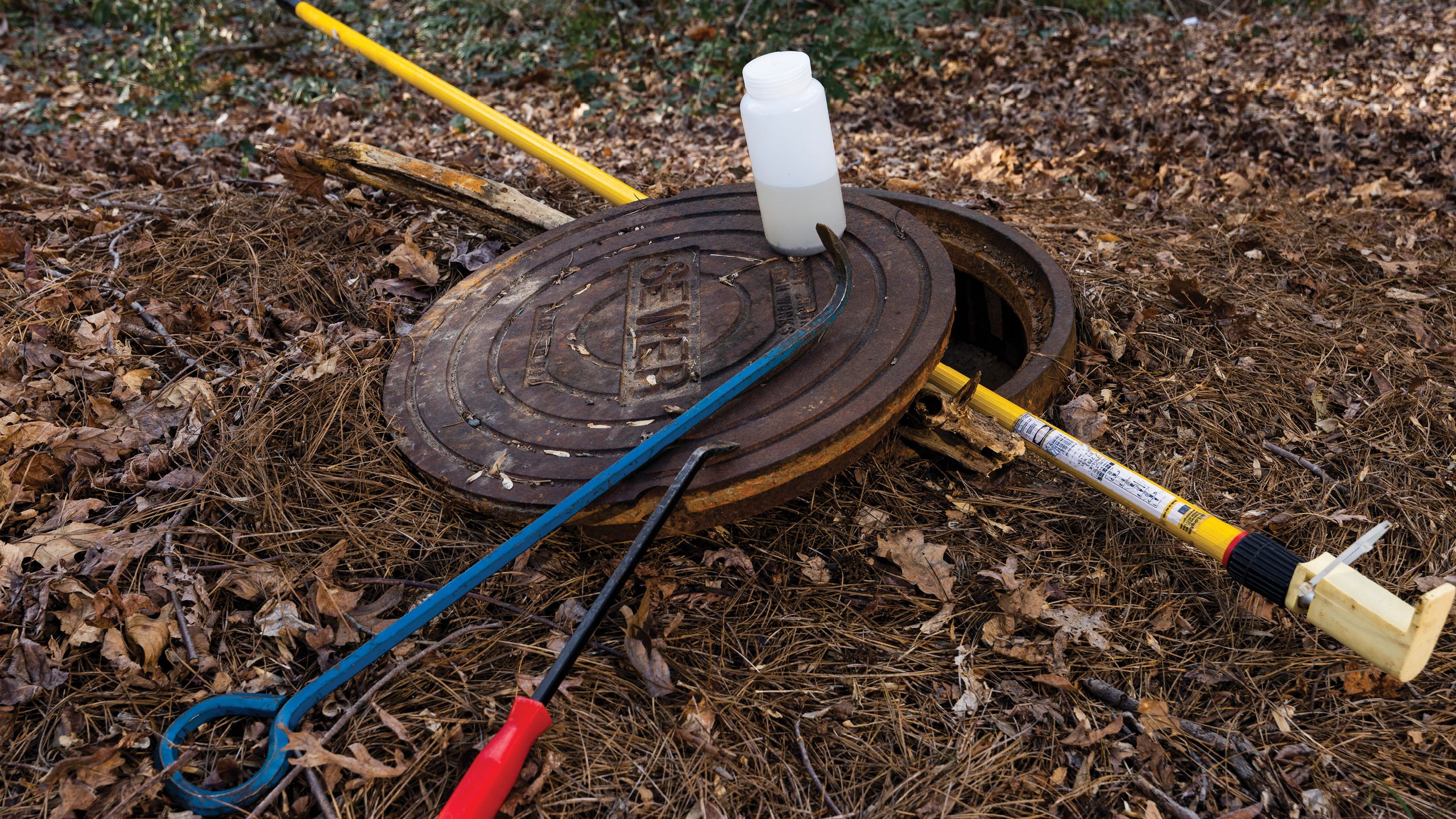 Tools are arranged over a manhole cover.