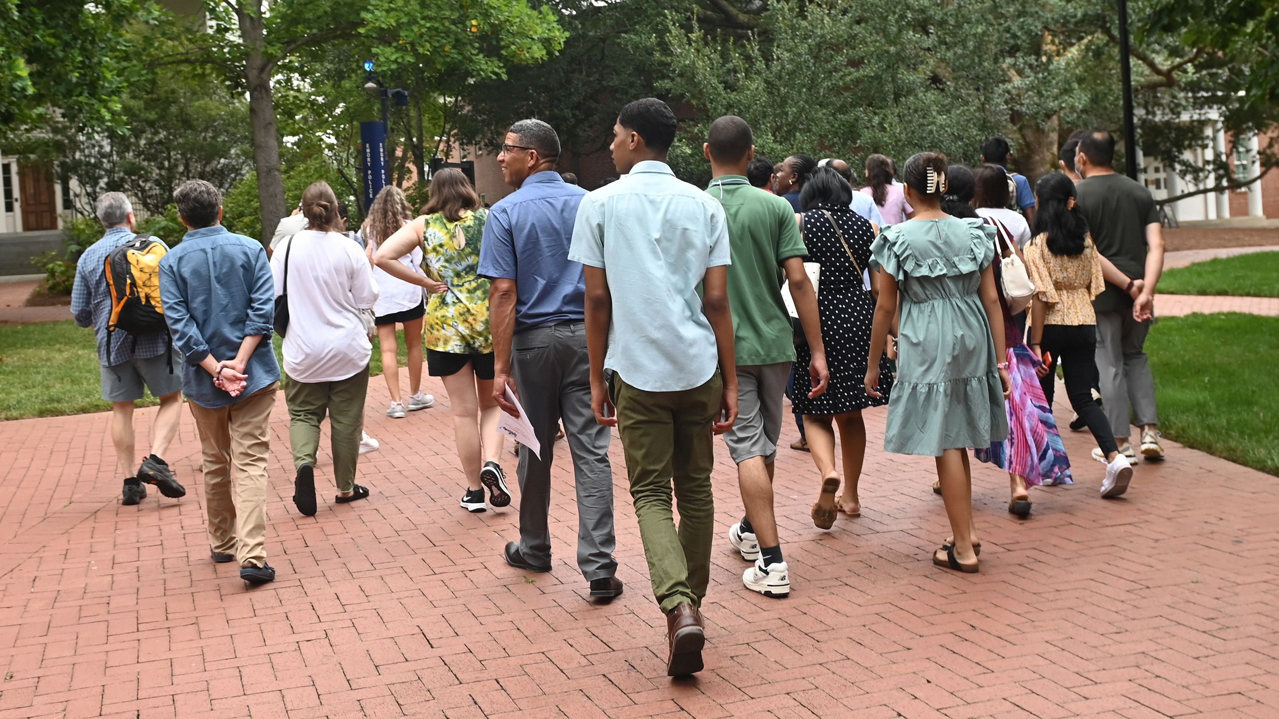 Mixed group of people walking through campus.