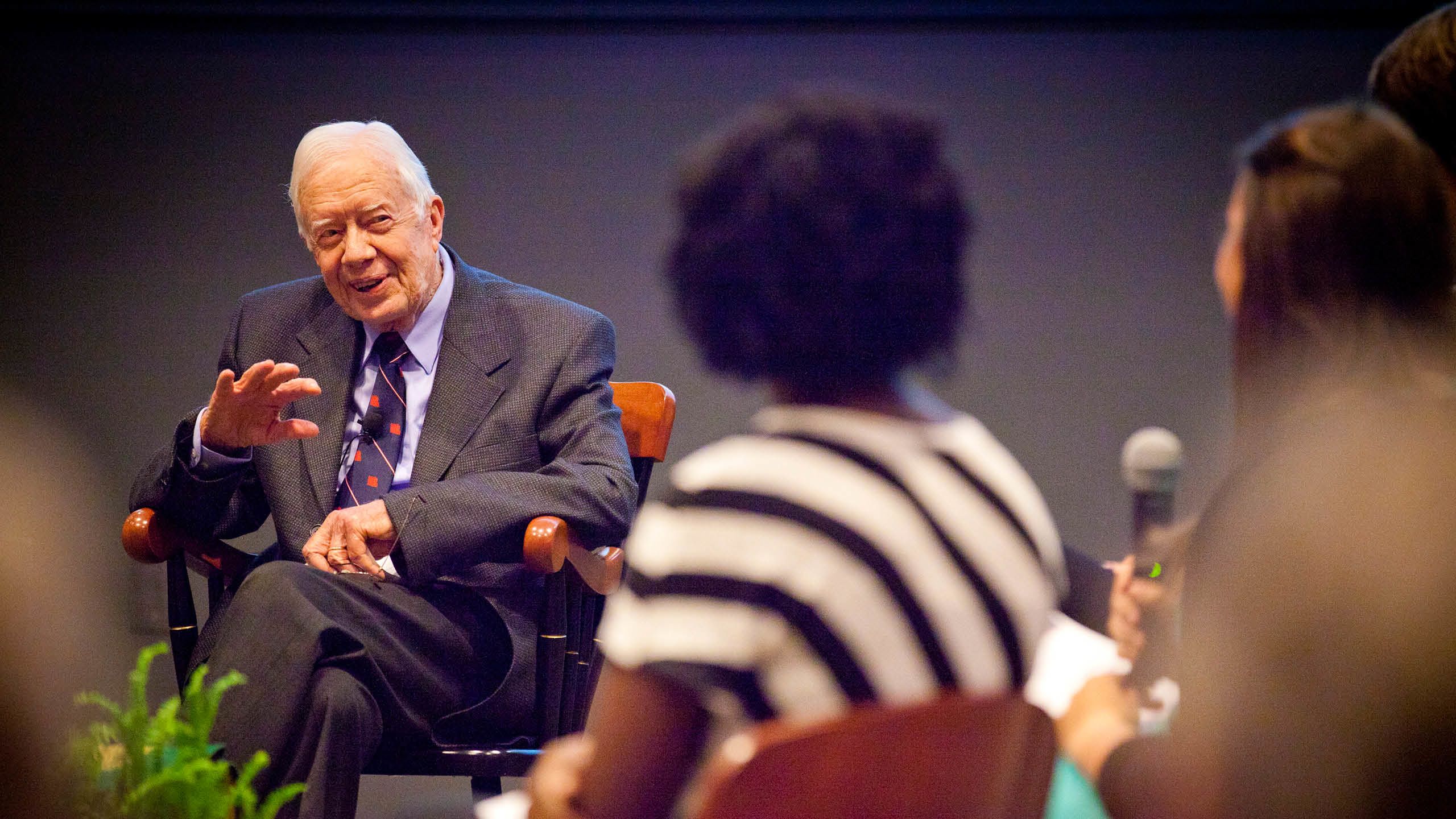 President Carter speaking with a Black Emory student with her back to the camera