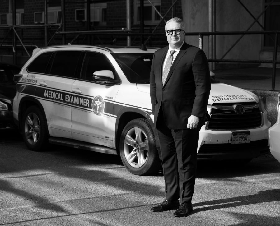 Photo of Jason Graham and an OCME SUV.