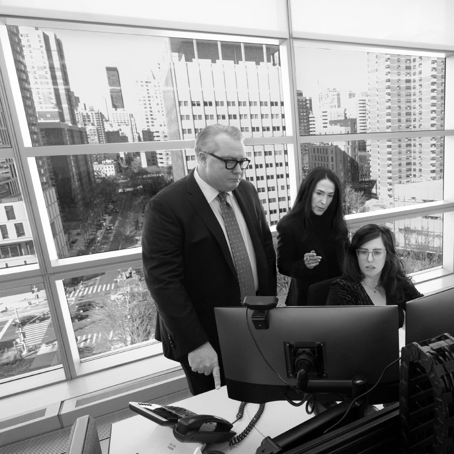Photo of New York City's top two medical examiners Jason Graham and Michele Solne (standing) oversee a relatively new investigations operations center.
